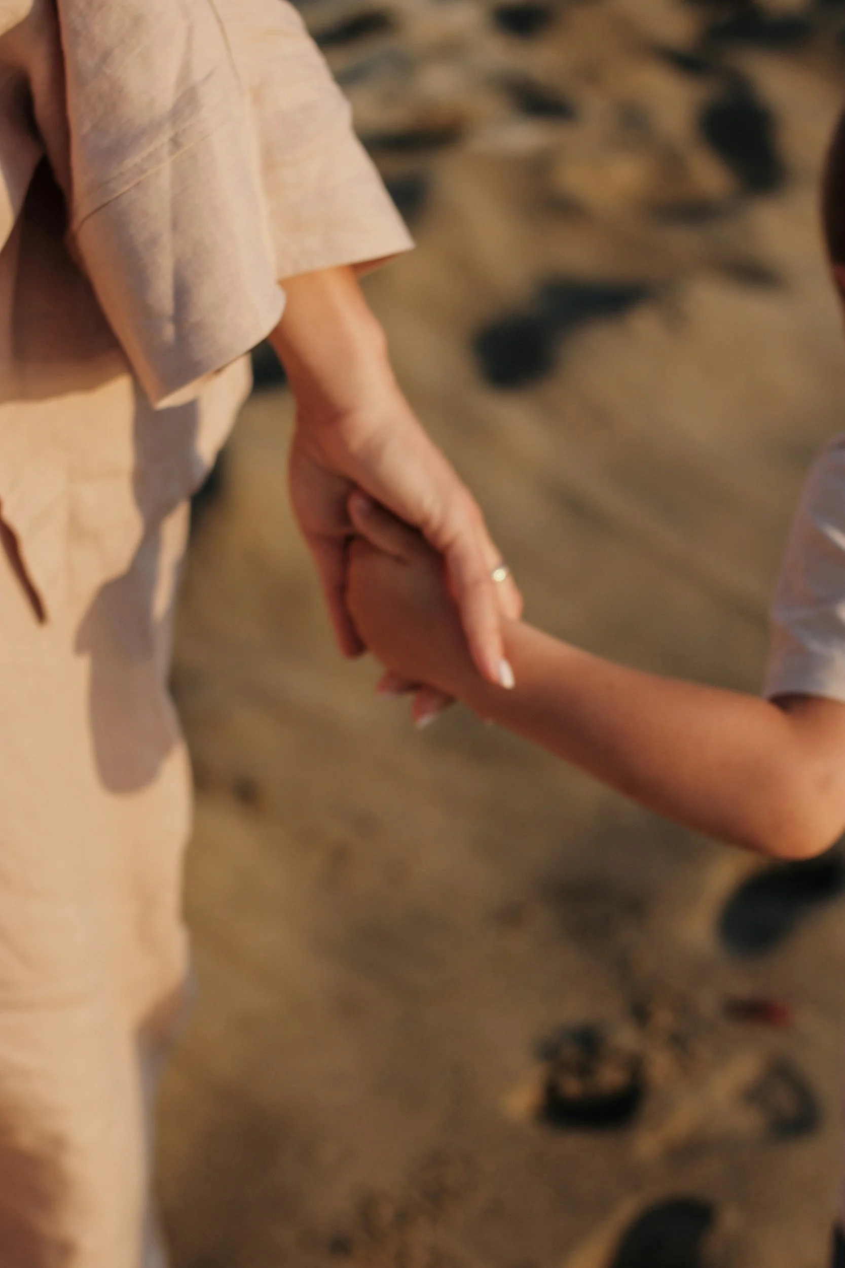 A close-up image of a woman's hand holding a child's hand.