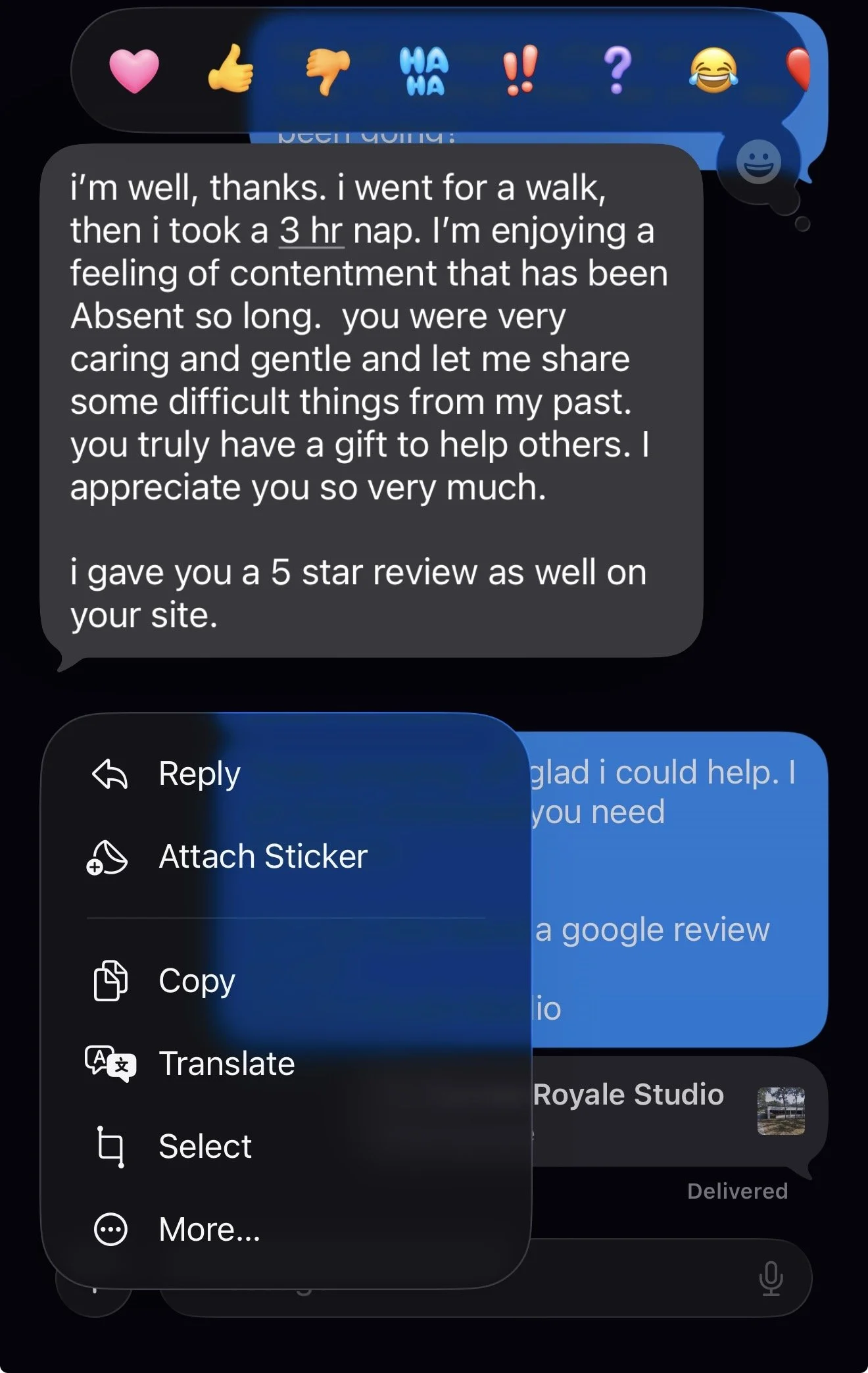 A close-up of a smartphone screen showing a messaging app with a dark background. The message contains a positive review praising someone's caring nature, mentioning a walk, a nap, and appreciation. The screen also displays a blue circle with a white
