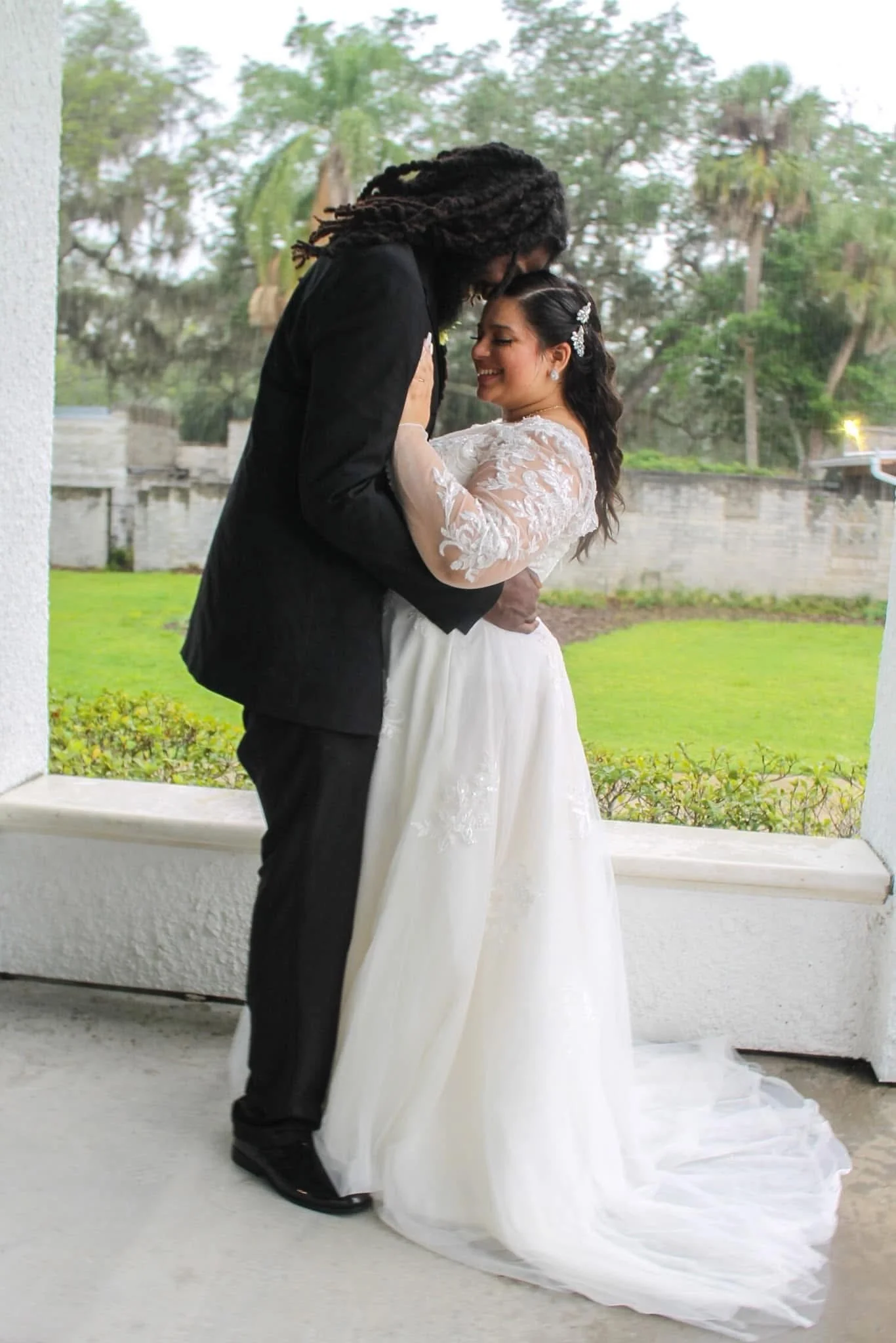Bride and groom sharing a romantic moment outdoors during their wedding day.