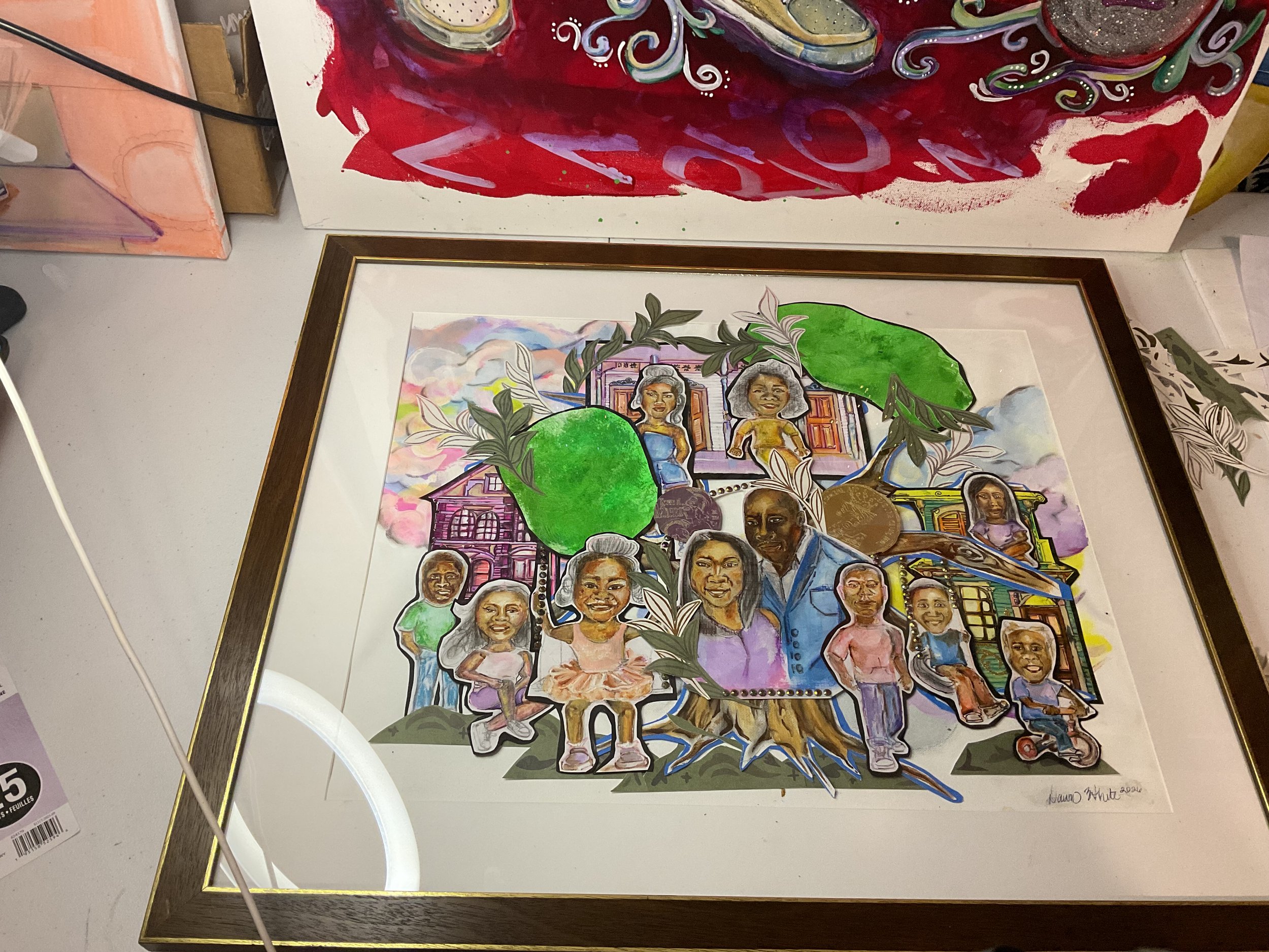 Colorful artwork featuring a collage of diverse faces, houses, plants, and abstract elements with vibrant colors including red, green, pink, and purple, signed in the bottom right corner.