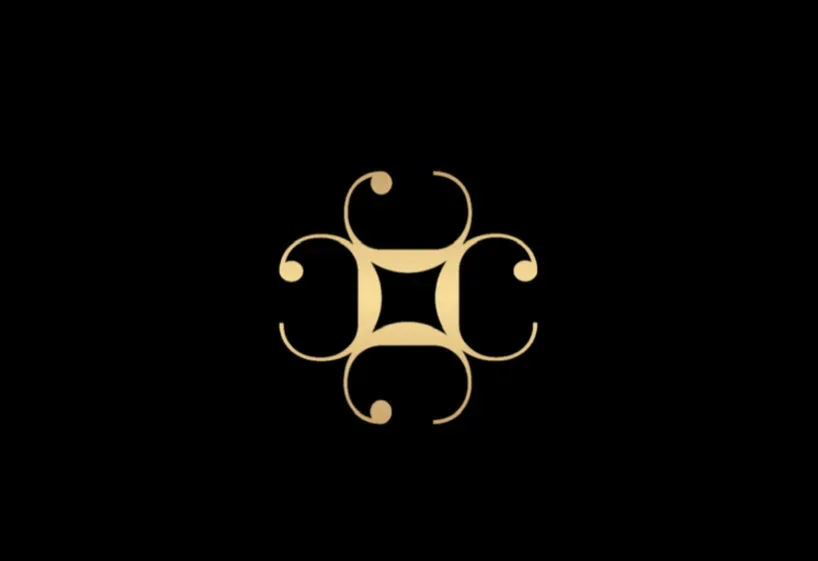 A gold ornate floral design on a black background.