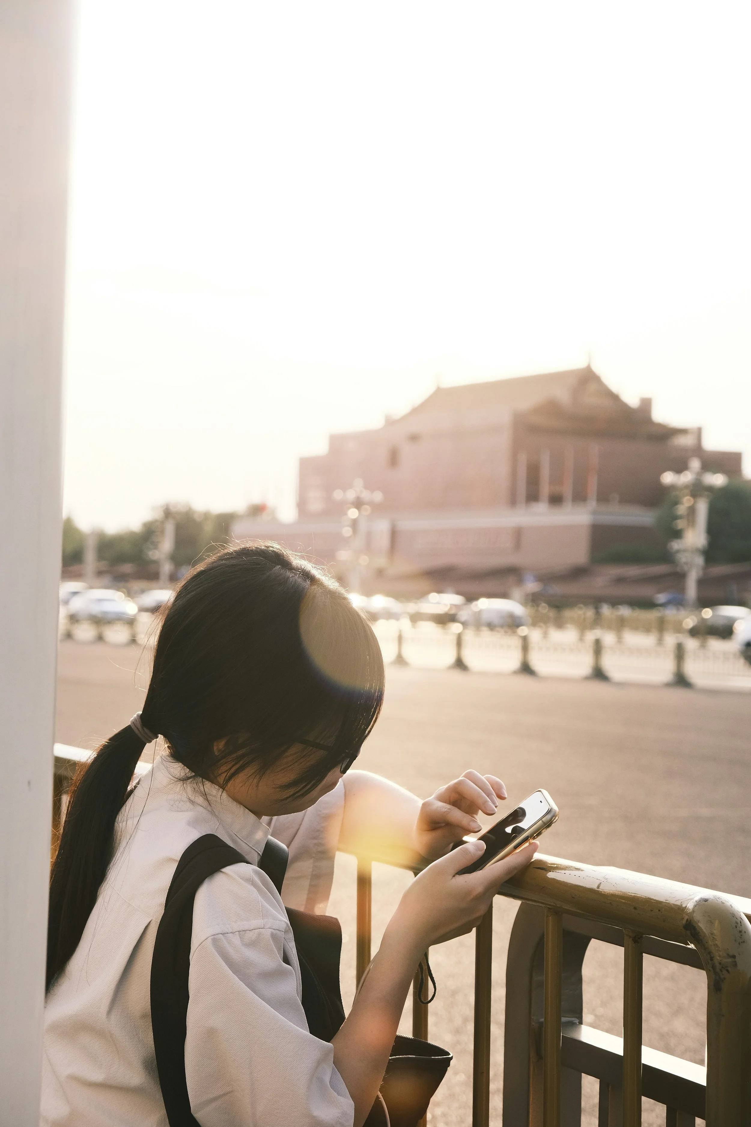 Woman in white button up outside on her cellphone