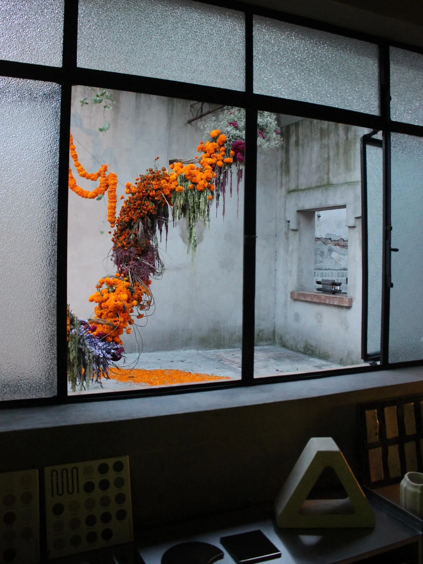 La vista de hoy desde el showroom, con la instalaci&oacute;n de D&iacute;a de Muertos dise&ntilde;ada por @xochipilliestudio en el patio de @hulegaleria