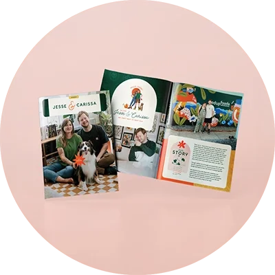 Open magazine and brochure on a pink background featuring photos of a couple with a dog, colorful illustrations, and a mural of animals.