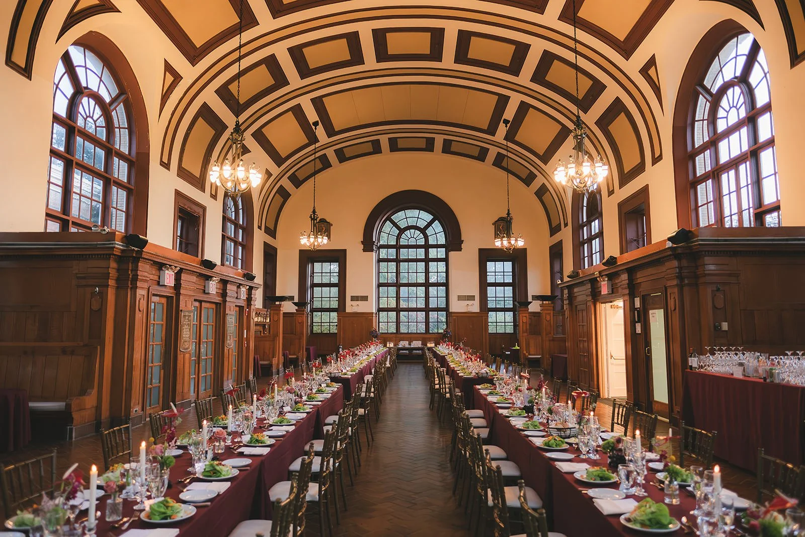 A wedding reception set up in a grand building with long rectangular tables running down either side