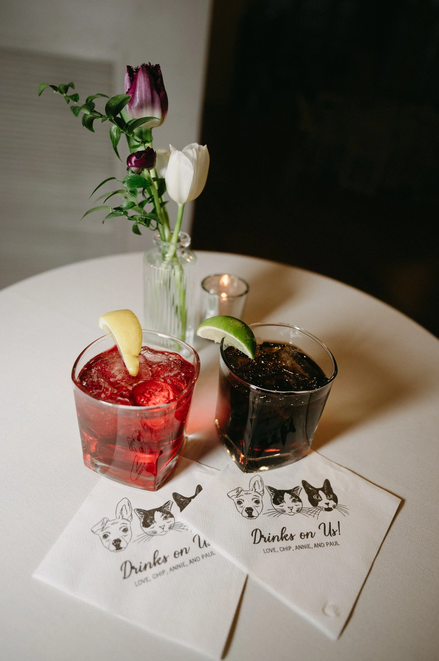 Two cocktails sitting on a table with custom printed napkins in front of them