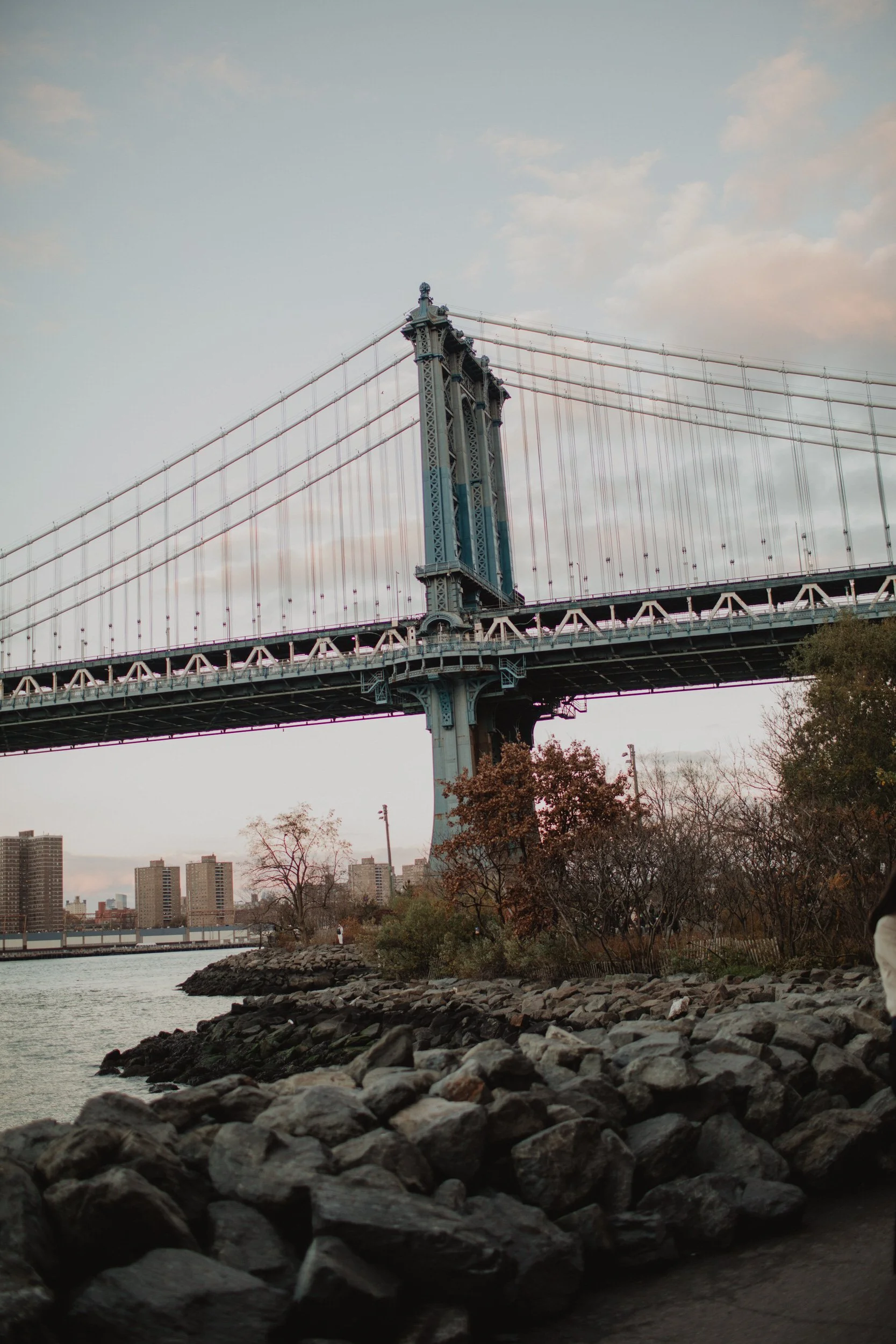 A large bridge with a rocky shoreline under it