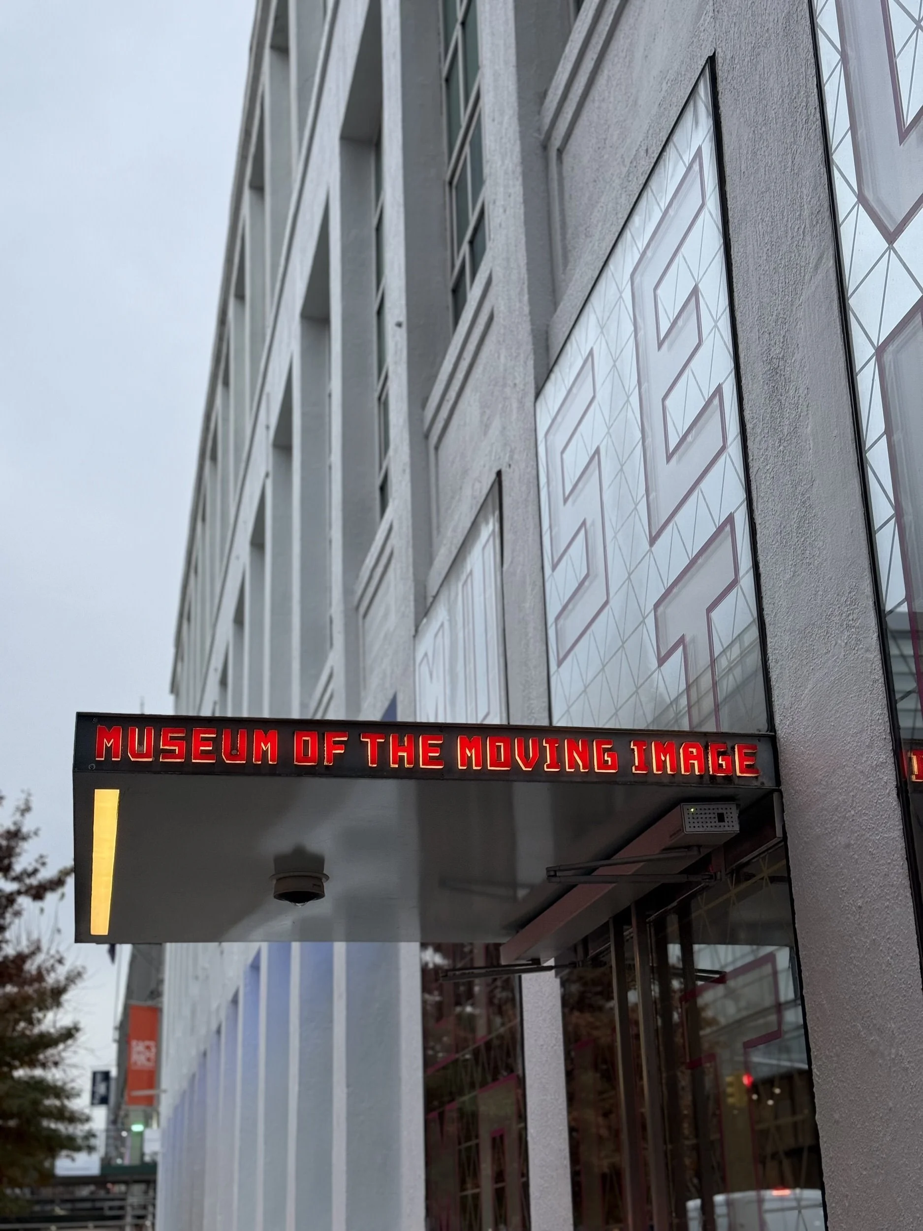 An overhang over the entrance to a building that reads "the museum of moving image"