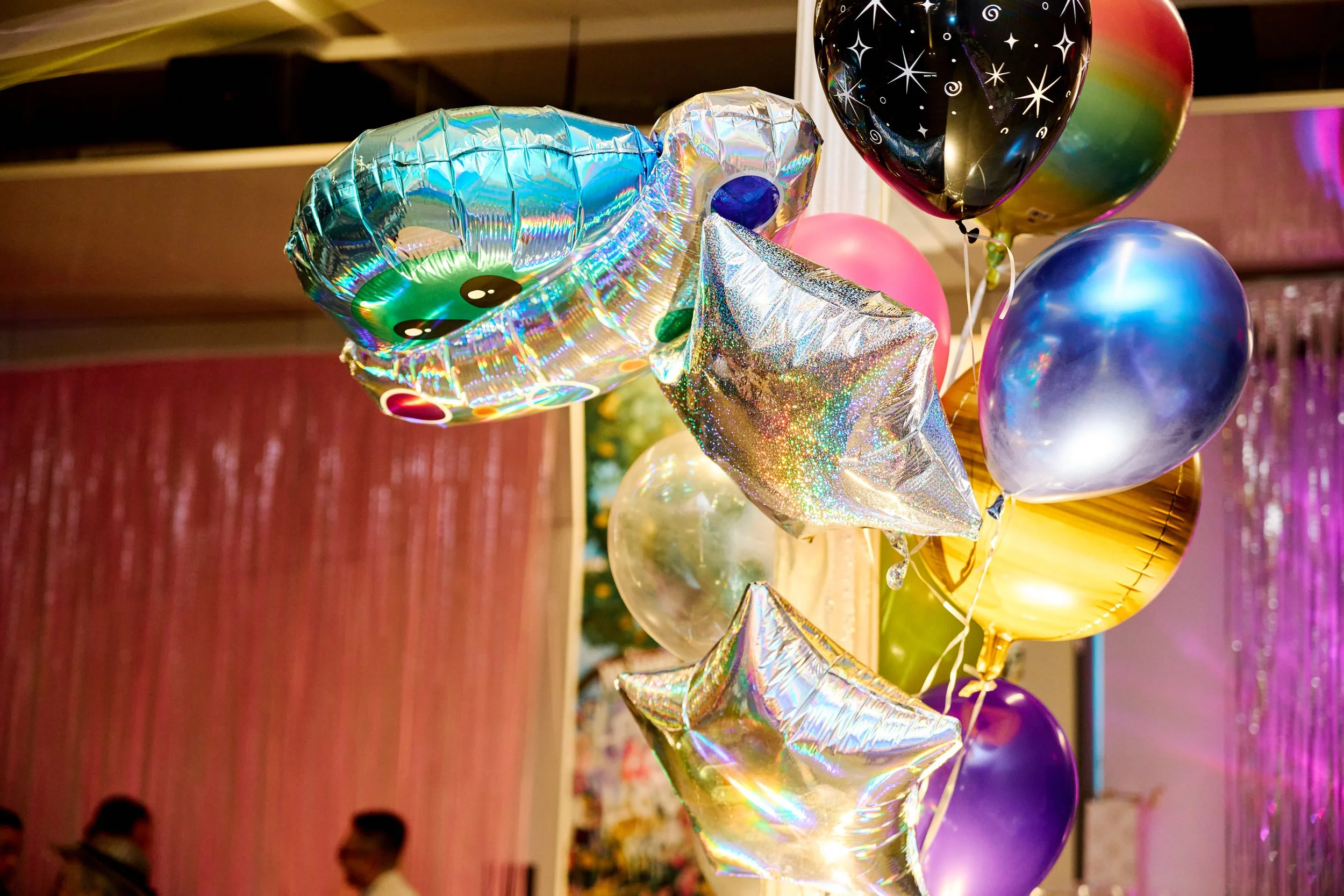 A bunch of colorful balloons in different shapes and sizes tied together