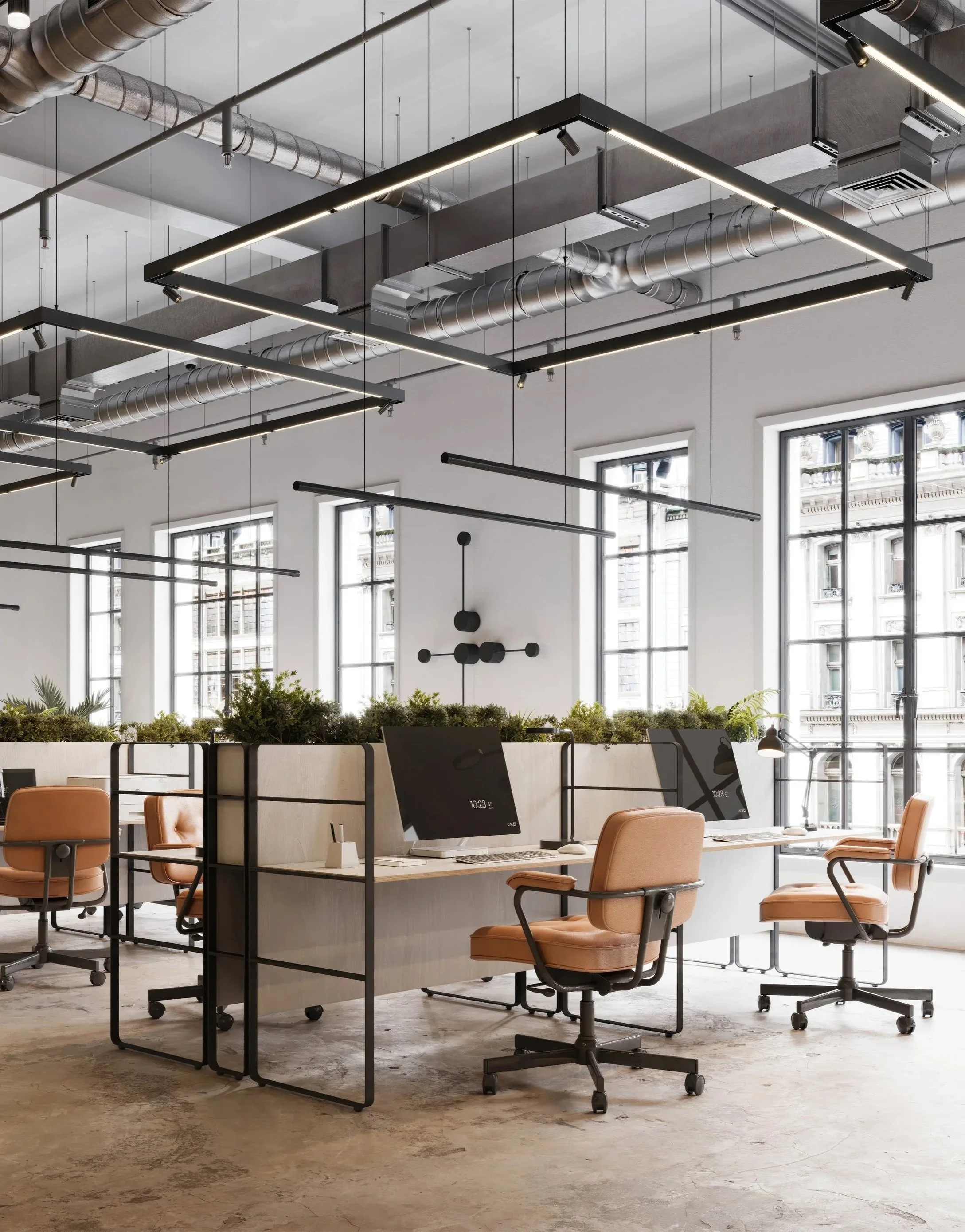 Modern open-concept office space with workstations, black computer monitors, peach-colored office chairs, large windows, and industrial ceiling lighting.