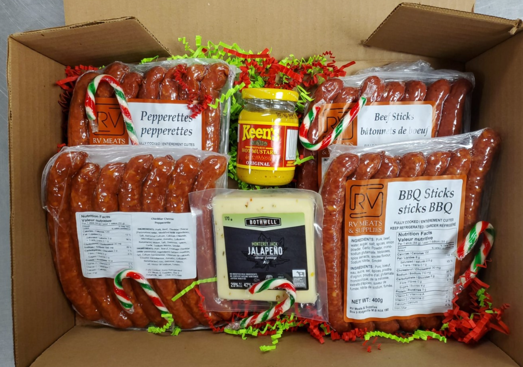 Gift Box containing four packs of sausages, a jar of Keen's hot mustard, a package of Monterey Jack jalapeno cheese, and a small candy cane.