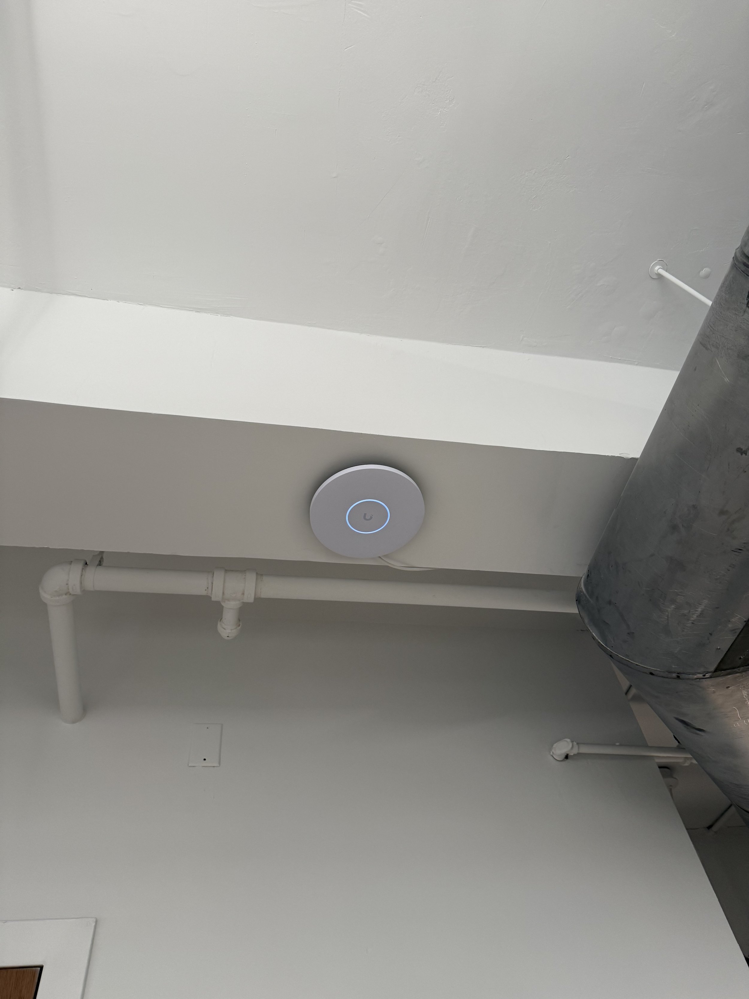 UniFi U7 Pro access point mounted in office ceiling.
