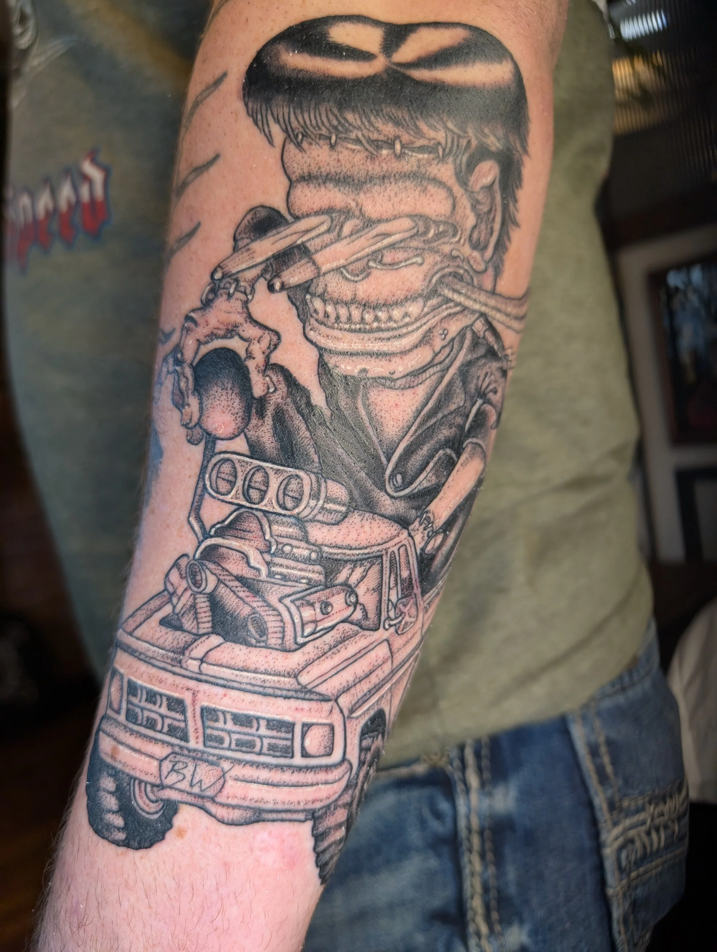 Black and gray tattoo of a woman with short hair, holding a cigarette, with automotive elements like a BMW logo and car parts incorporated into the design.