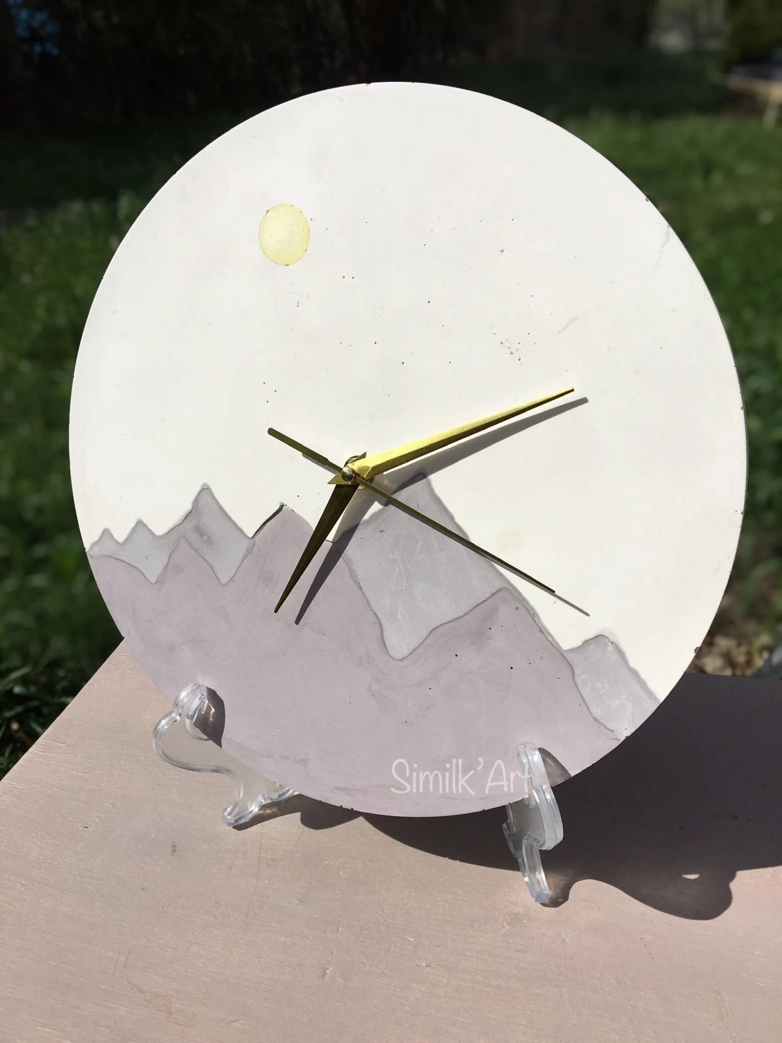 Round Clock made of Jesmonite (mineral material) representing mountains and the sun