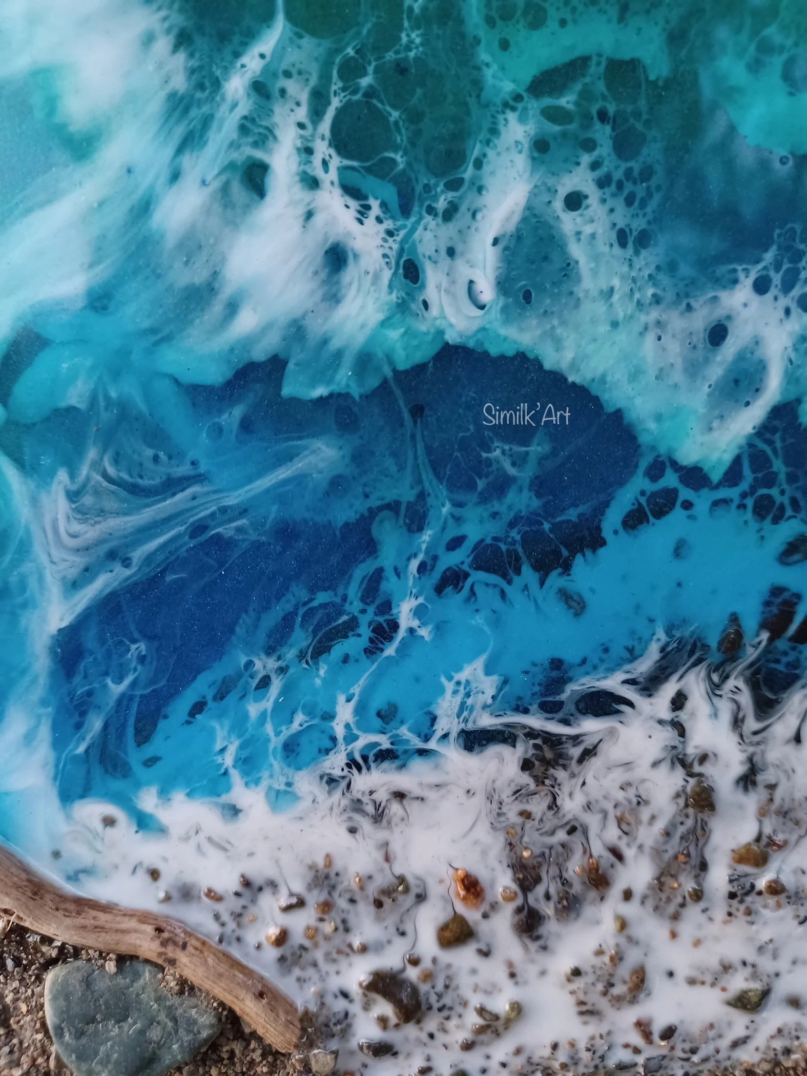 Close-up of a Resin Ocean themed piece with some small rocks, sand and a piece of driftwood all from the Similkameen Valley.