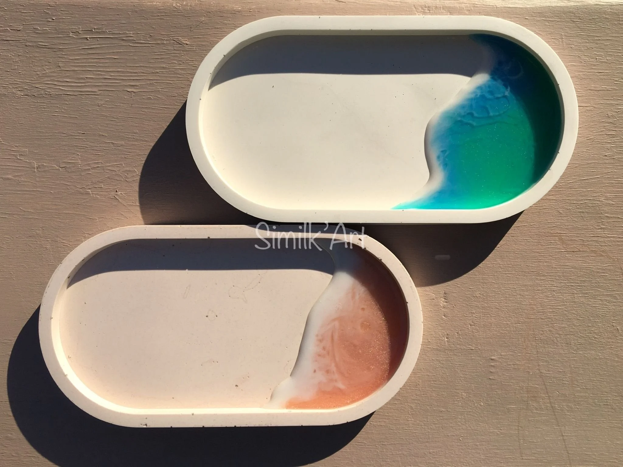 Two Oval trinket trays made of Jesmonite (mineral based) and resin in the corners simulating de ocean with waves