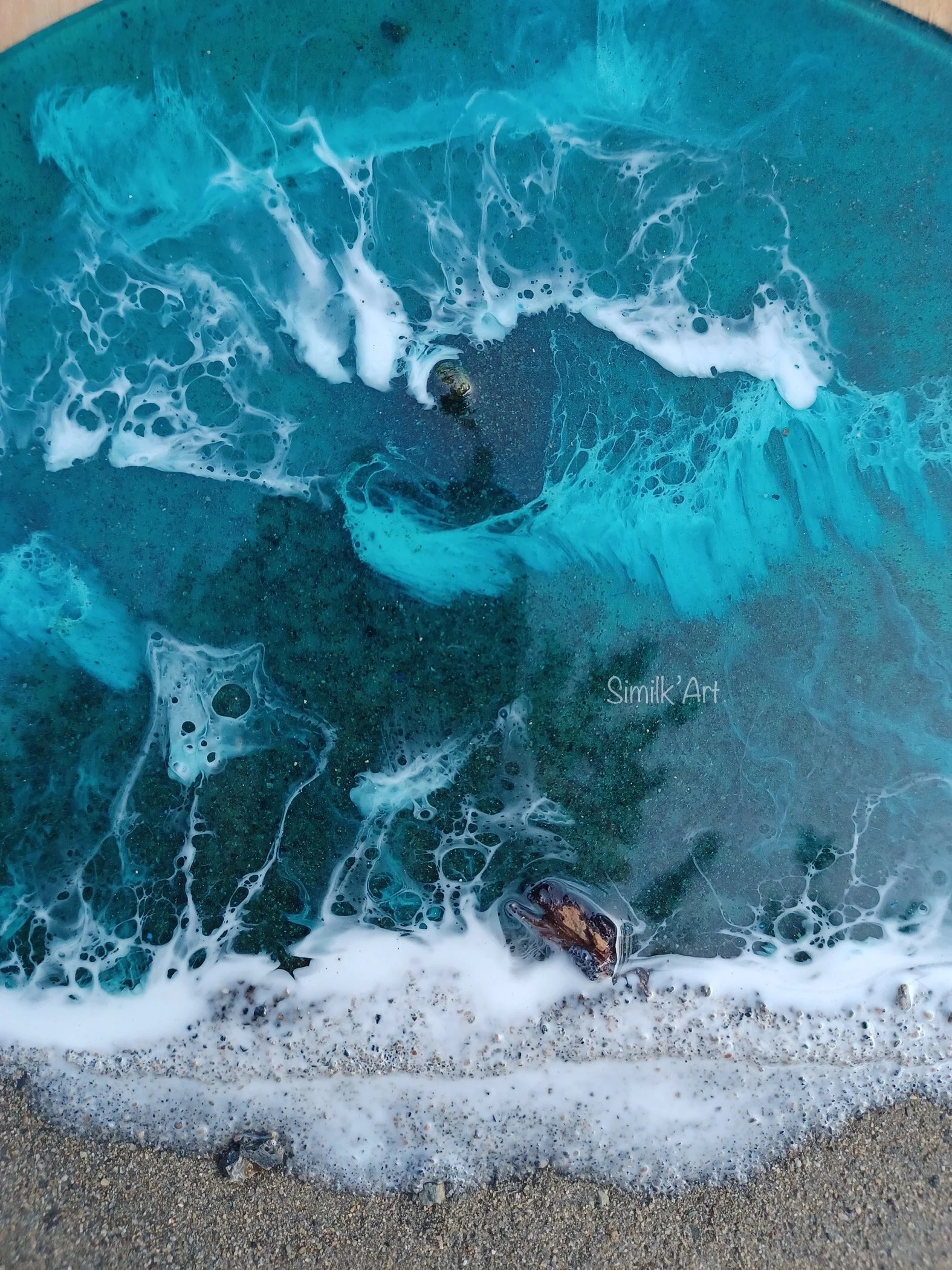 Close-up of ocean waves washing onto a sandy beach with foam and shells.
