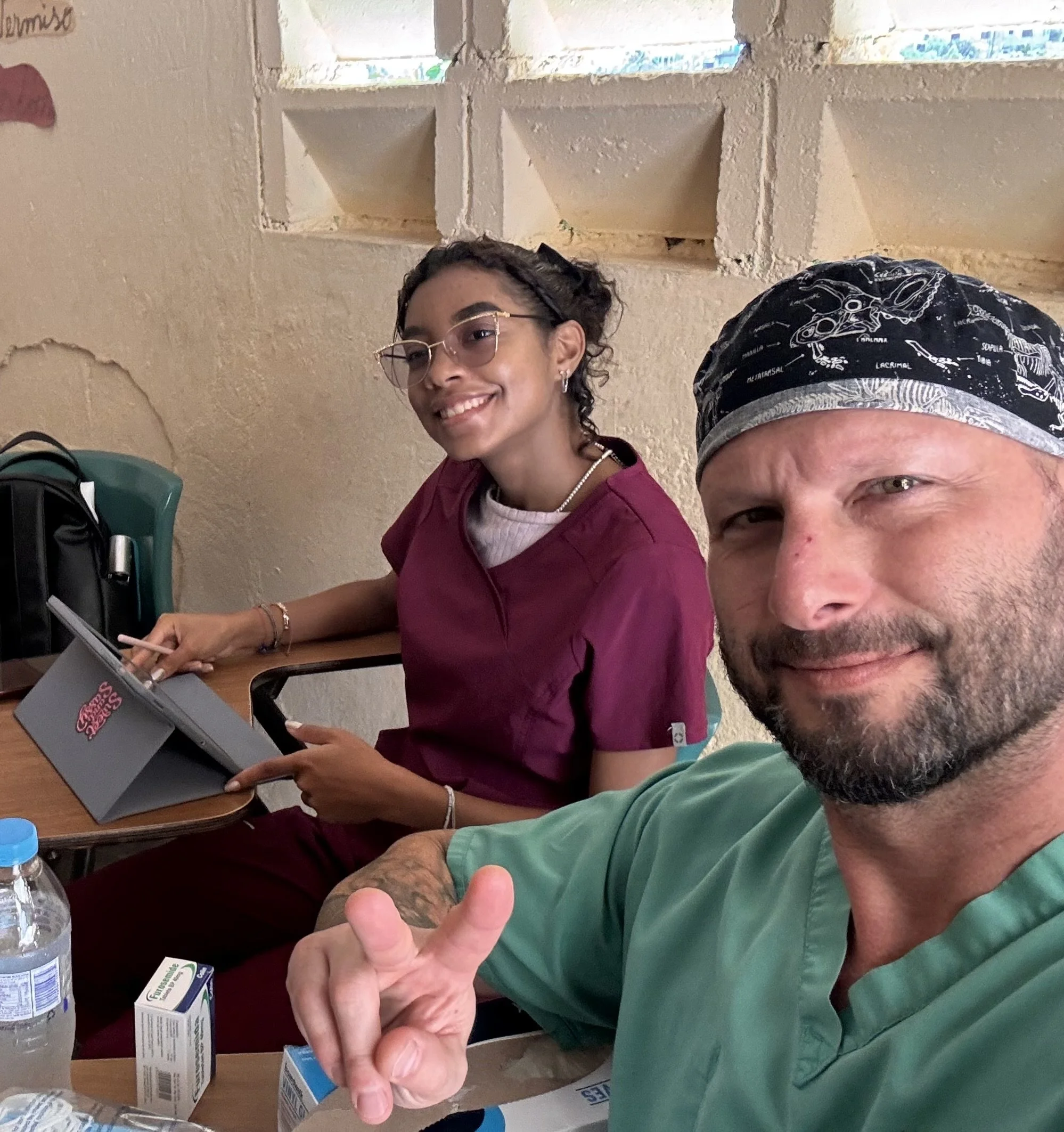 Healthier Futures International volunteers in scrubs smile at a clinic station during 2024 medical mission