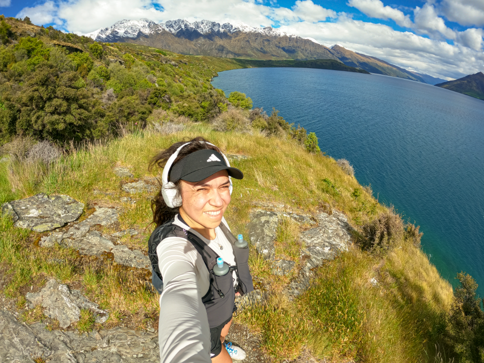 Mujer haciendo trekking con vistas hacia Queenstown