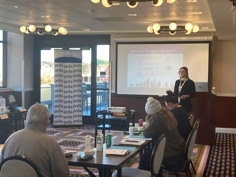 Lydia Chastain is giving a presentation with a screen titled 'What is a Foreign Trade Zone?'  for attendees of IDEA