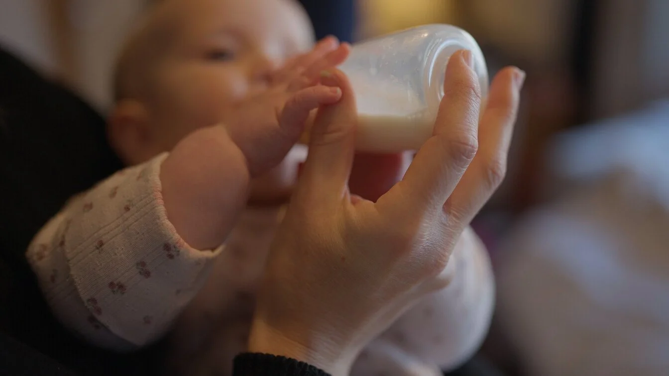A baby drinks from a bottle