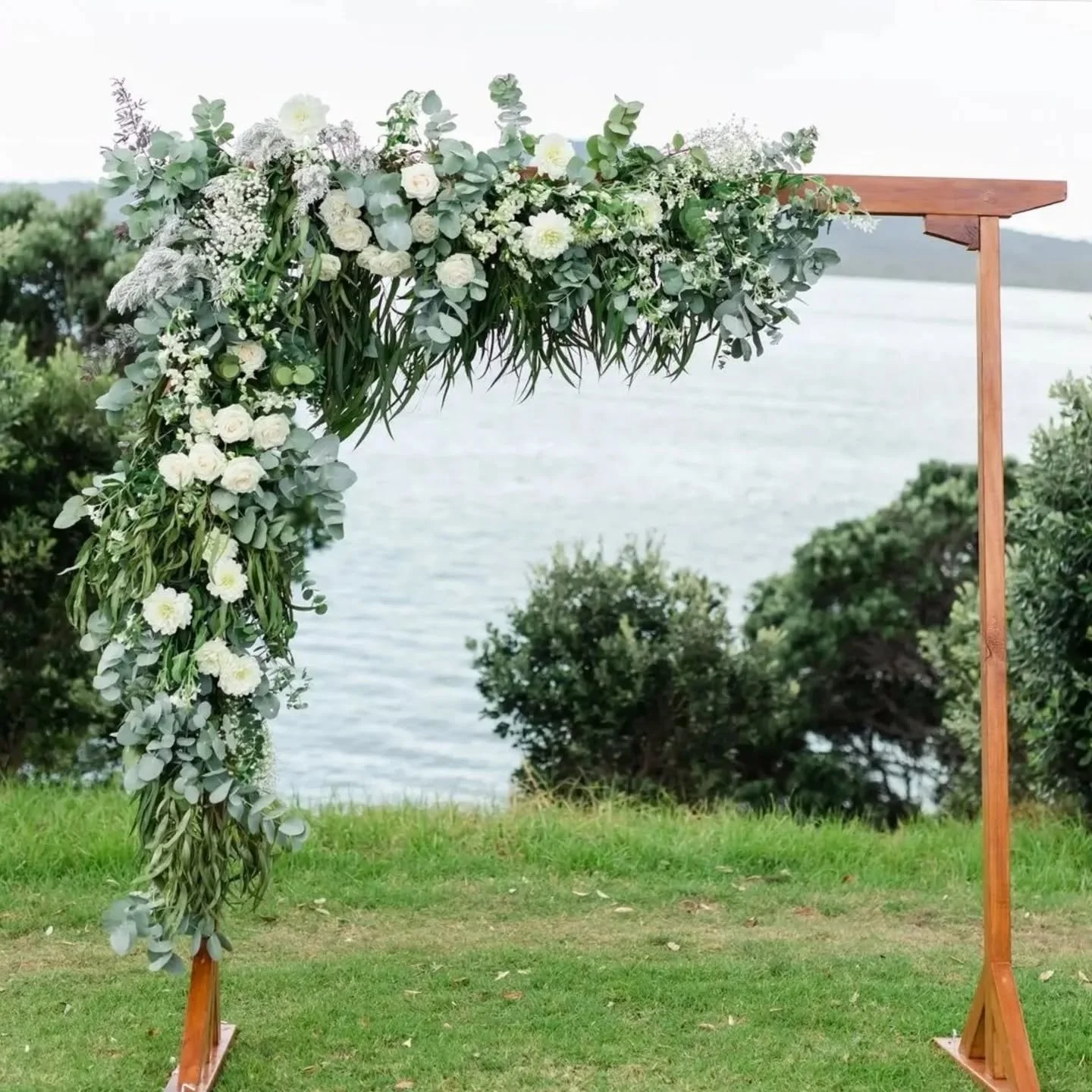 The brown wooden arch, all dressed up and ready for the big day. Flowers by @branchandbloomnz