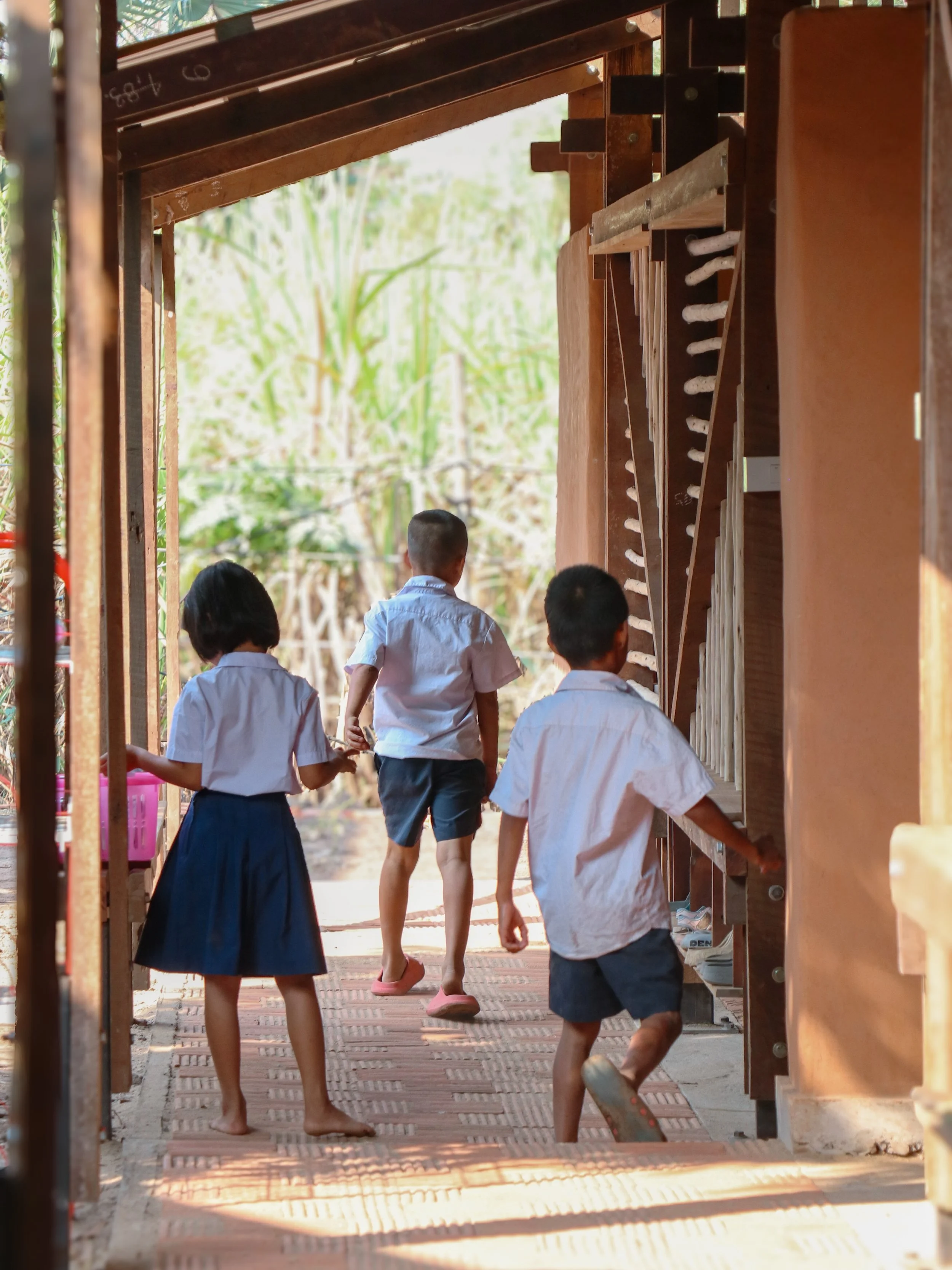 Thailand 2026 - AH YONE OO, Mae Sot

Ein vorgelagerter Korridor erschlie&szlig;t die Klassenr&auml;ume, spendet Schatten und bildet zugleich eine Aufenthalts- und &Uuml;bergangszone zwischen Au&szlig;enraum und Unterricht. Er ist nicht nur Erschlie&s