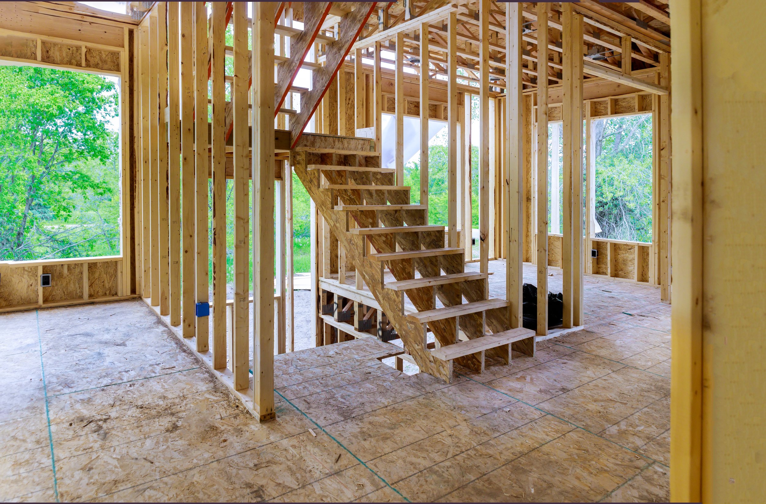 new-construction-beam-construction-house-framed-ground-up-framing-against-blue-sky.jpg