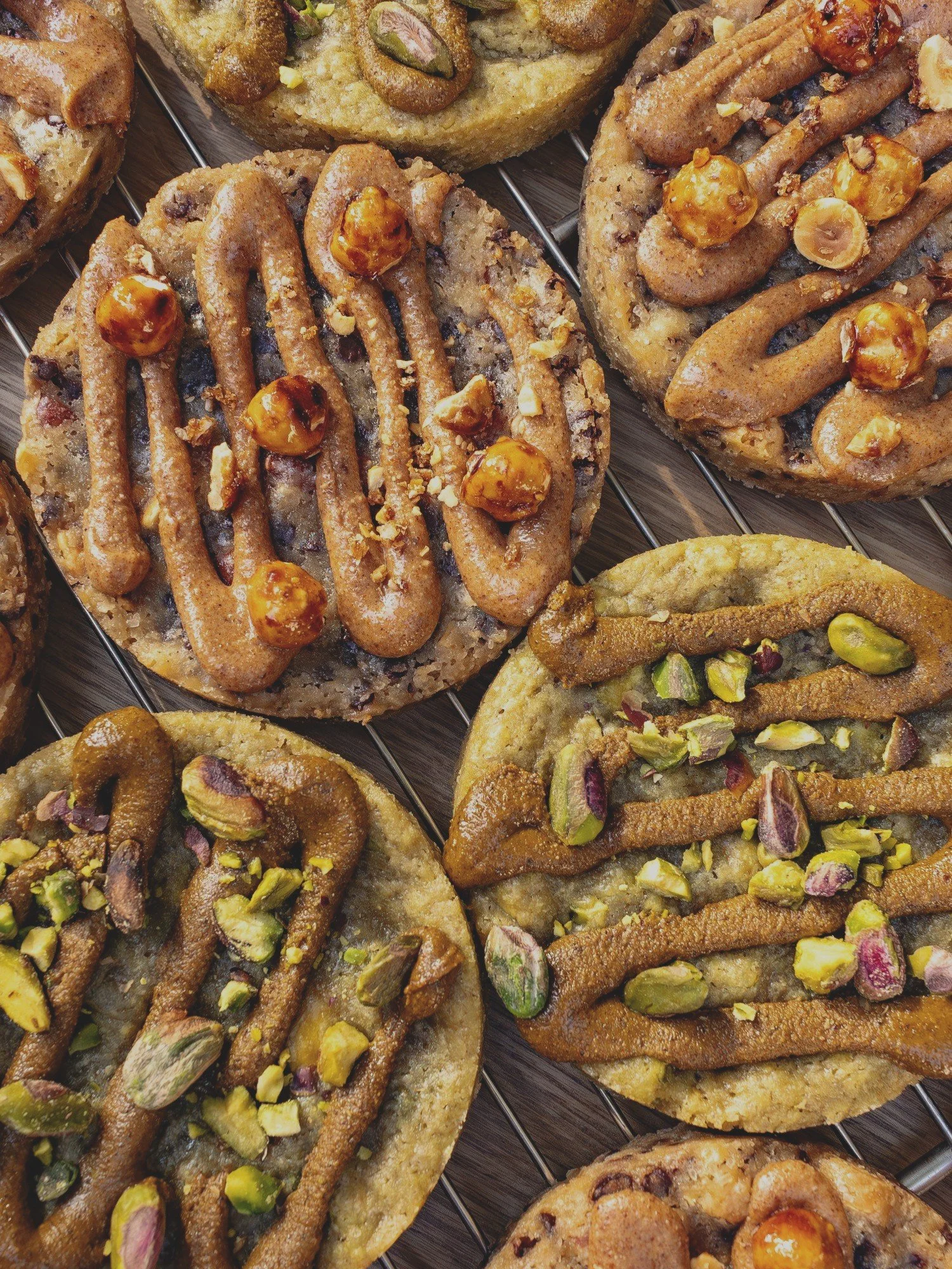 Galletas decoradas con pasta de azúcar y nueces o pistachos, algunas con chocolate y nueces, otras con pasta de azúcar de diferentes colores y decoraciones.