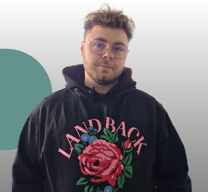 A young professional therapist in a black "Land Back" hoodies with a large rose on the front