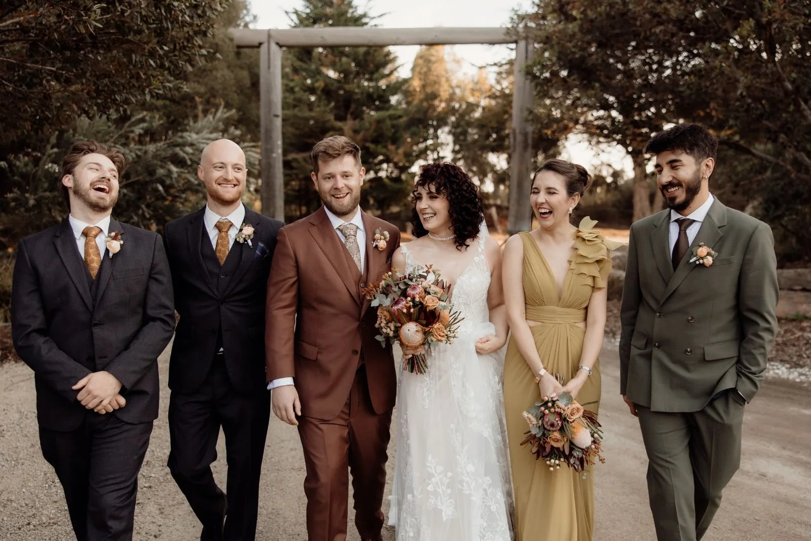 laughs amongst closest friend in the wedding party in the golden hour