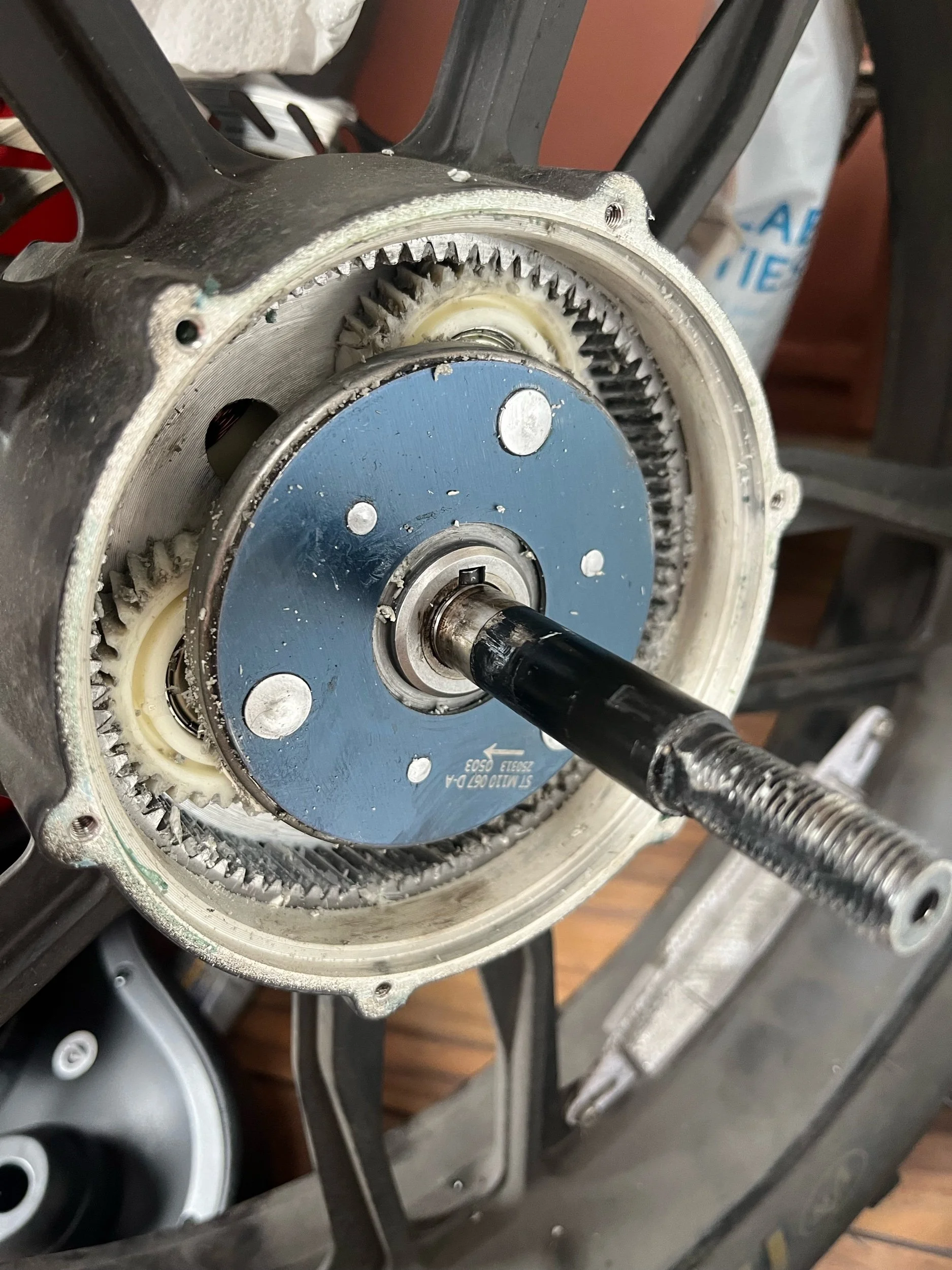 Close-up of a disassembled electric motor, showing the stator, rotor shaft, and internal gear mechanisms mounted on a work stand.