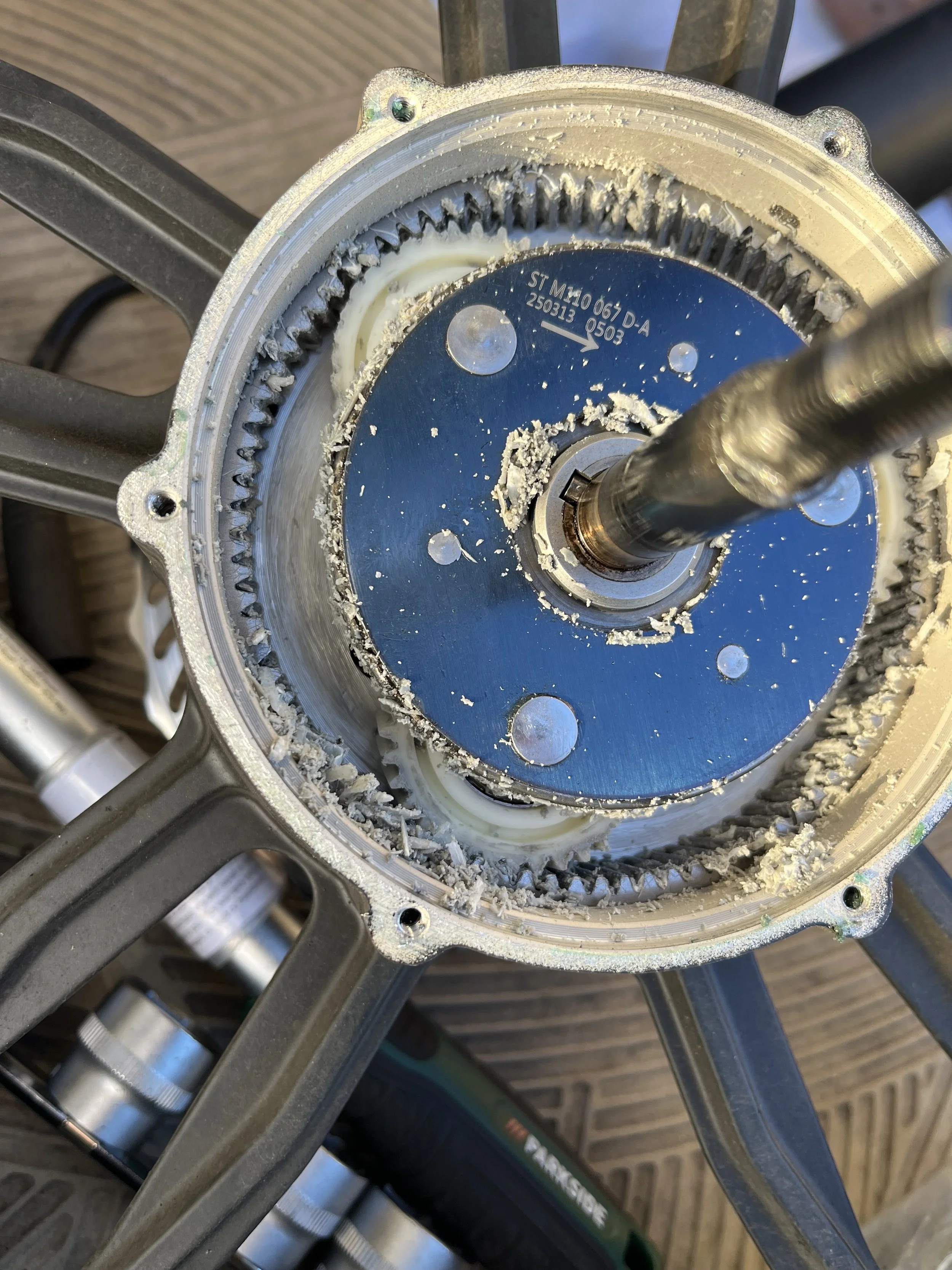 Close-up of a disassembled mechanical part showing that the planetary gears inside an electric bike motor have been chewed up because of extensive use. This happens a lot for Delivery riders as they work long continuous hours. eRYD repairs with ease