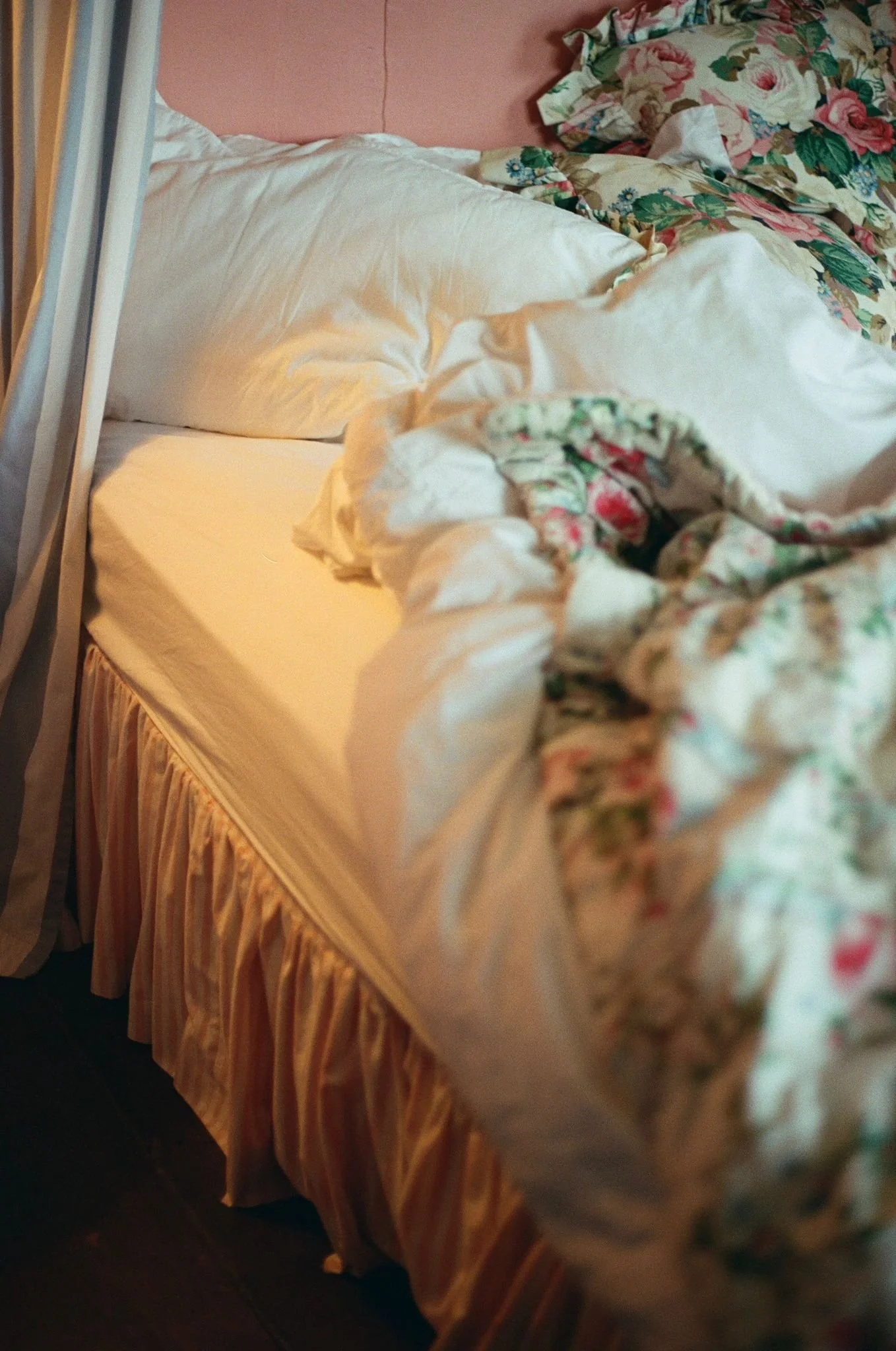 Dreamy cottage bedroom with peach painted walls, layered textiles, feminine cottagecore interiors at Dot Cottage Rye