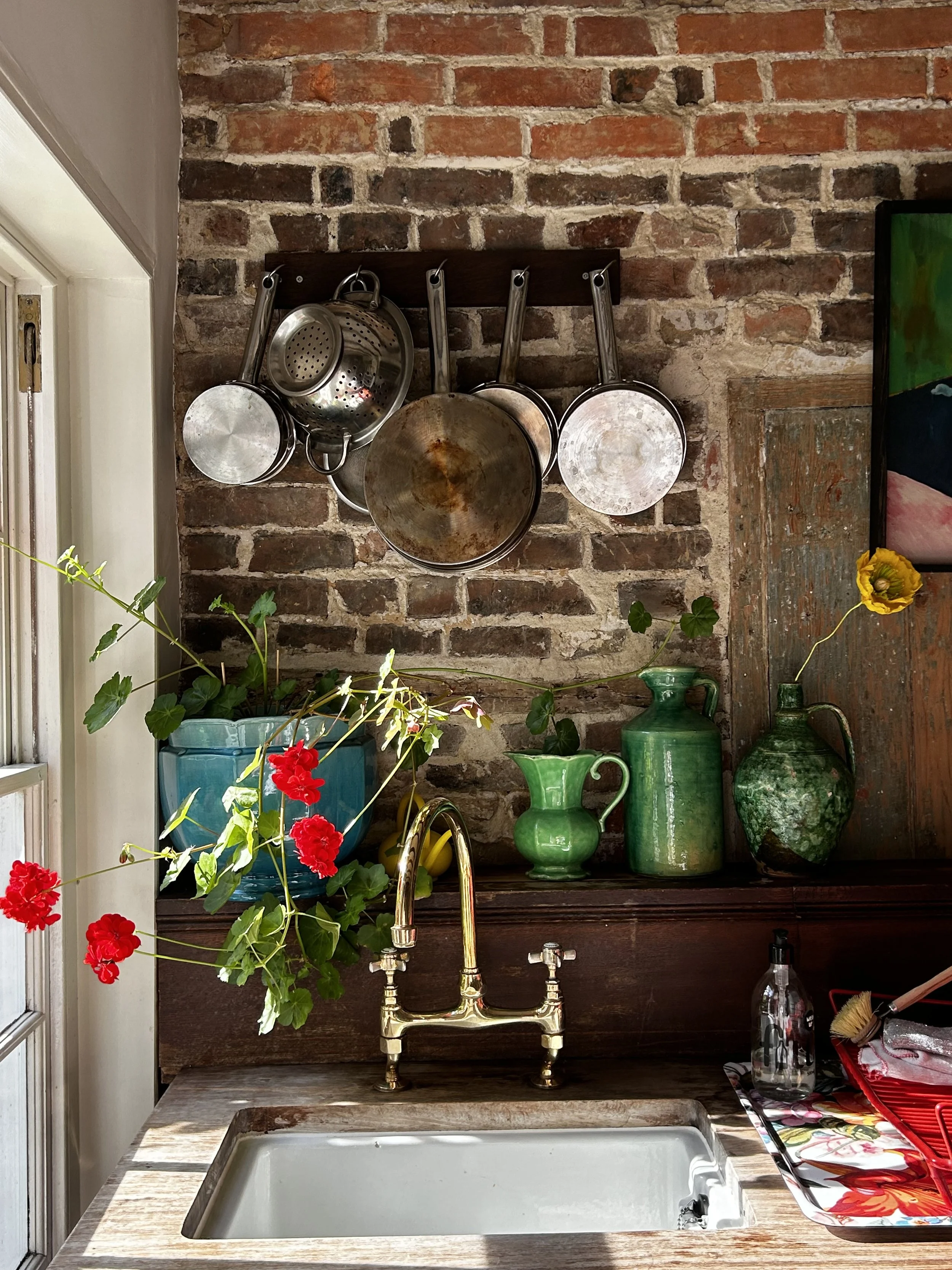 Characterful cottage kitchen with reclaimed cabinets and exposed brick wall at Dot Cottage Rye East Sussex