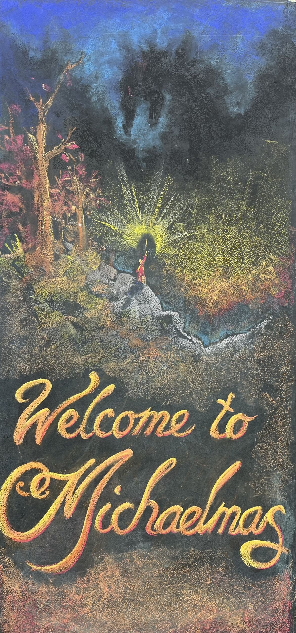 A chalkboard with a colorful drawing of a scene with trees, rocks, a girl in a red dress, and a glowing yellow light. The words 'Welcome to Michaelmas' are written in large, decorative yellow and pink script at the bottom.
