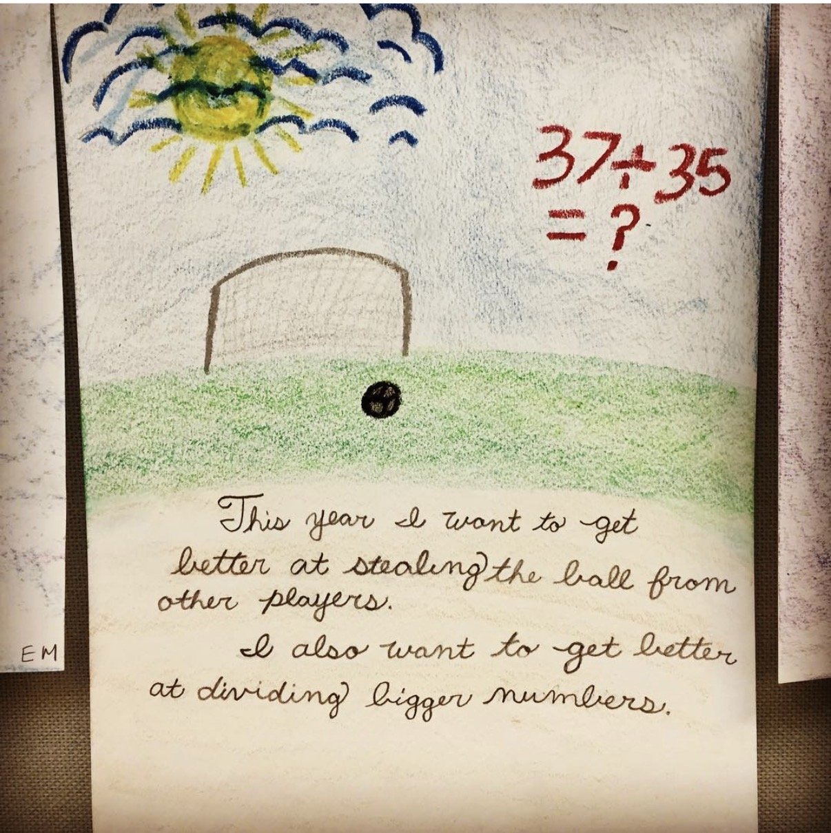 Drawing of a sunny sky with clouds, a soccer goal, and a soccer ball on a green field. The math problem 37.4 divided by 35 is written in red, with a question mark. Handwritten note below states the goal to improve stealing from other players and divi