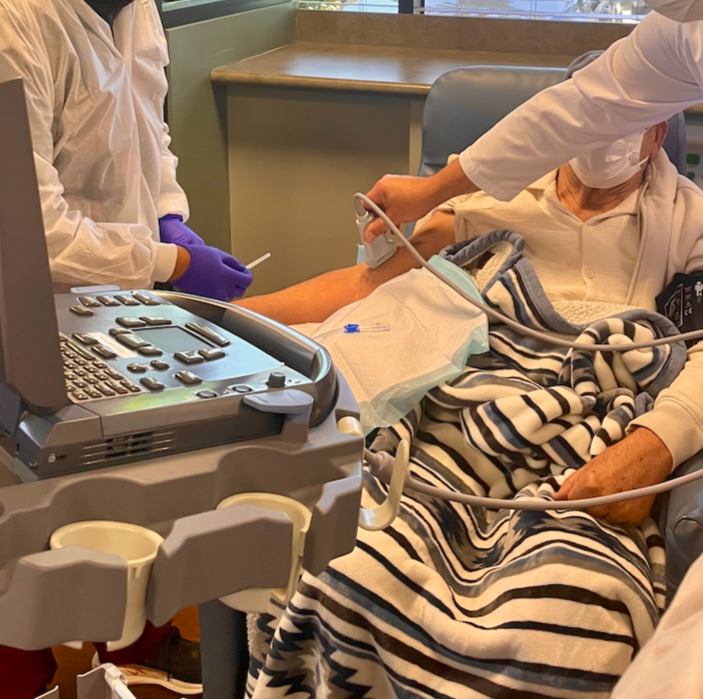 Medical staff performing an ultrasound guided access for dialysis on a patient.