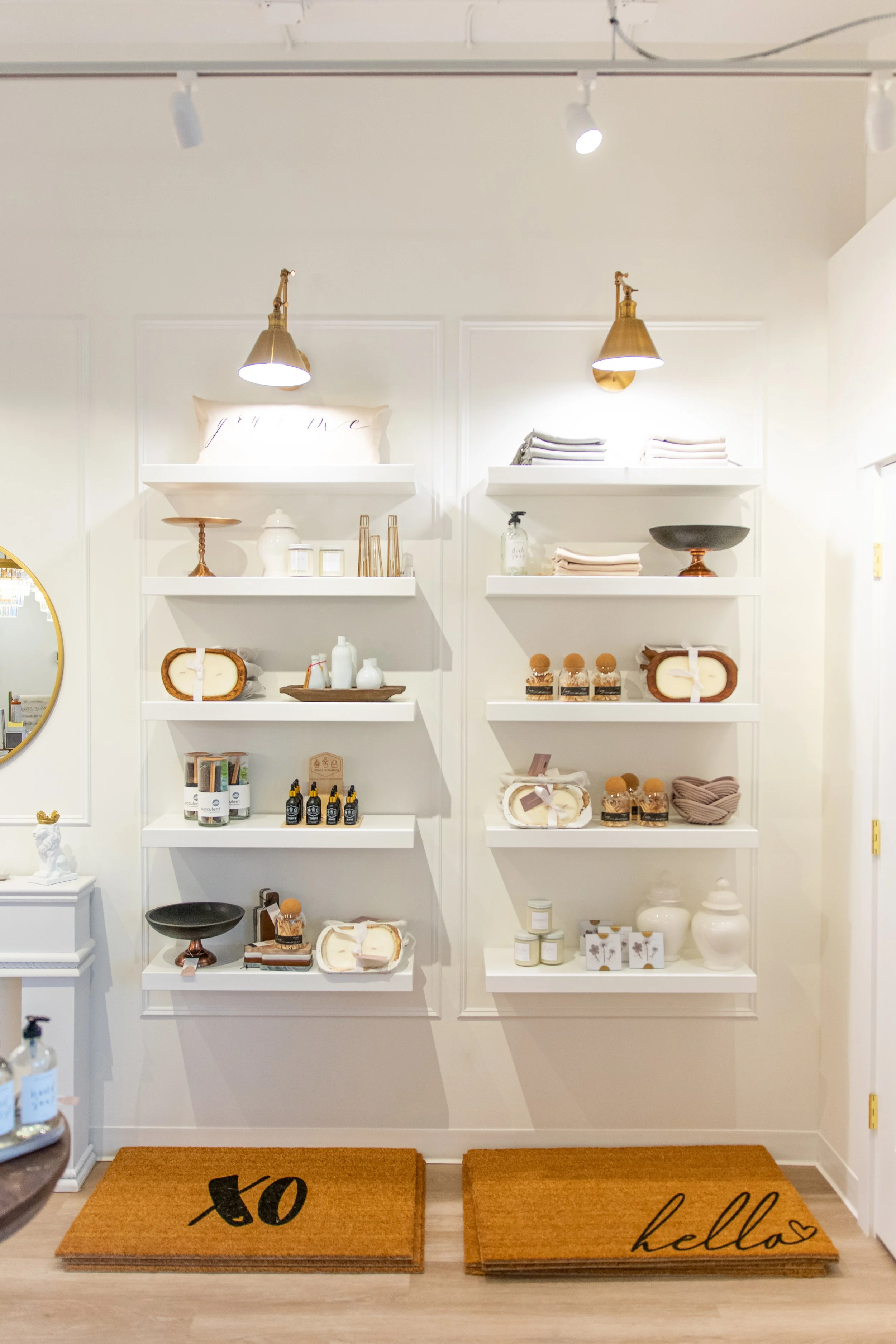 Display shelves with decorative items, candles, and assorted home decor in a boutique store.