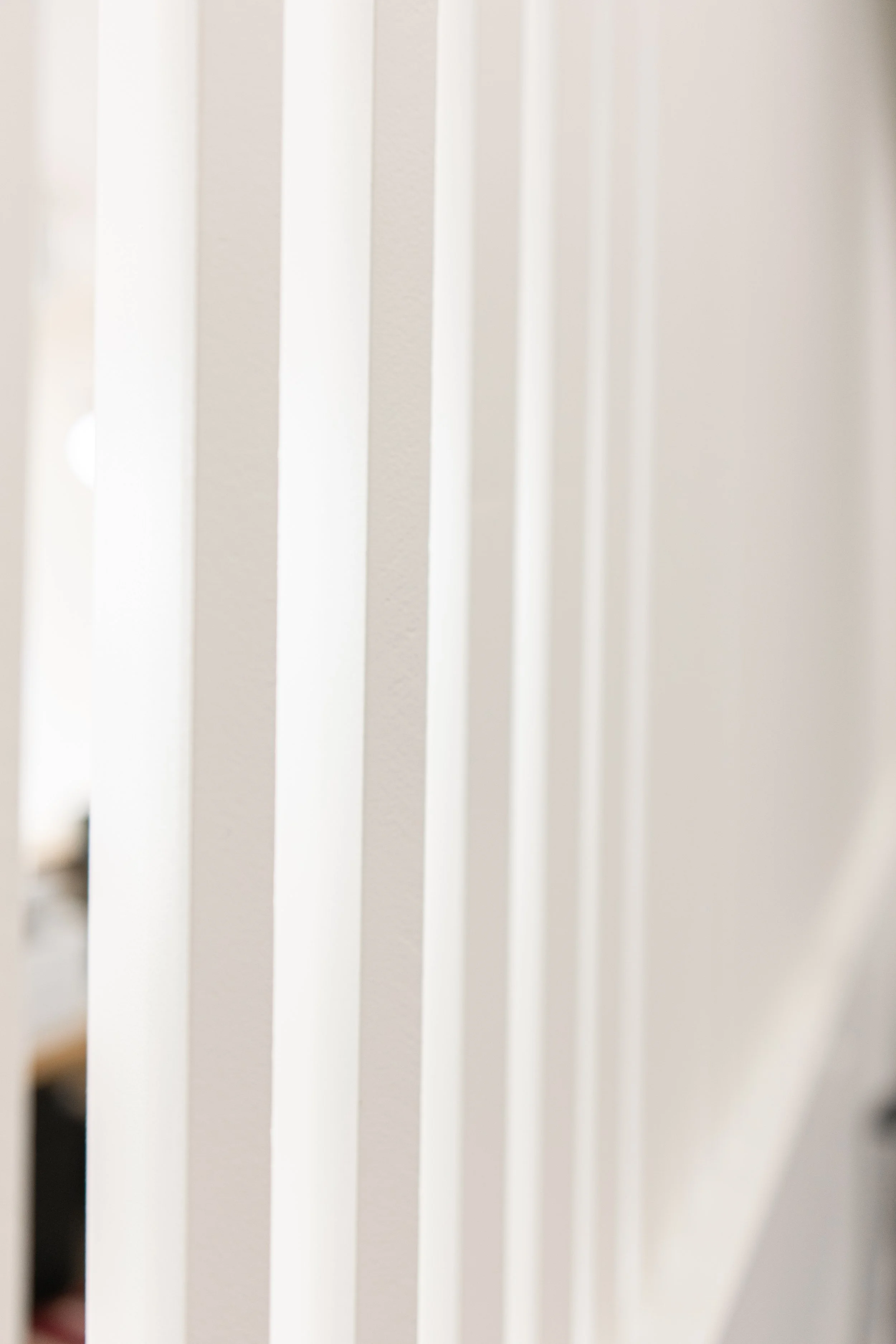 Close-up of white vertical blinds in a window.