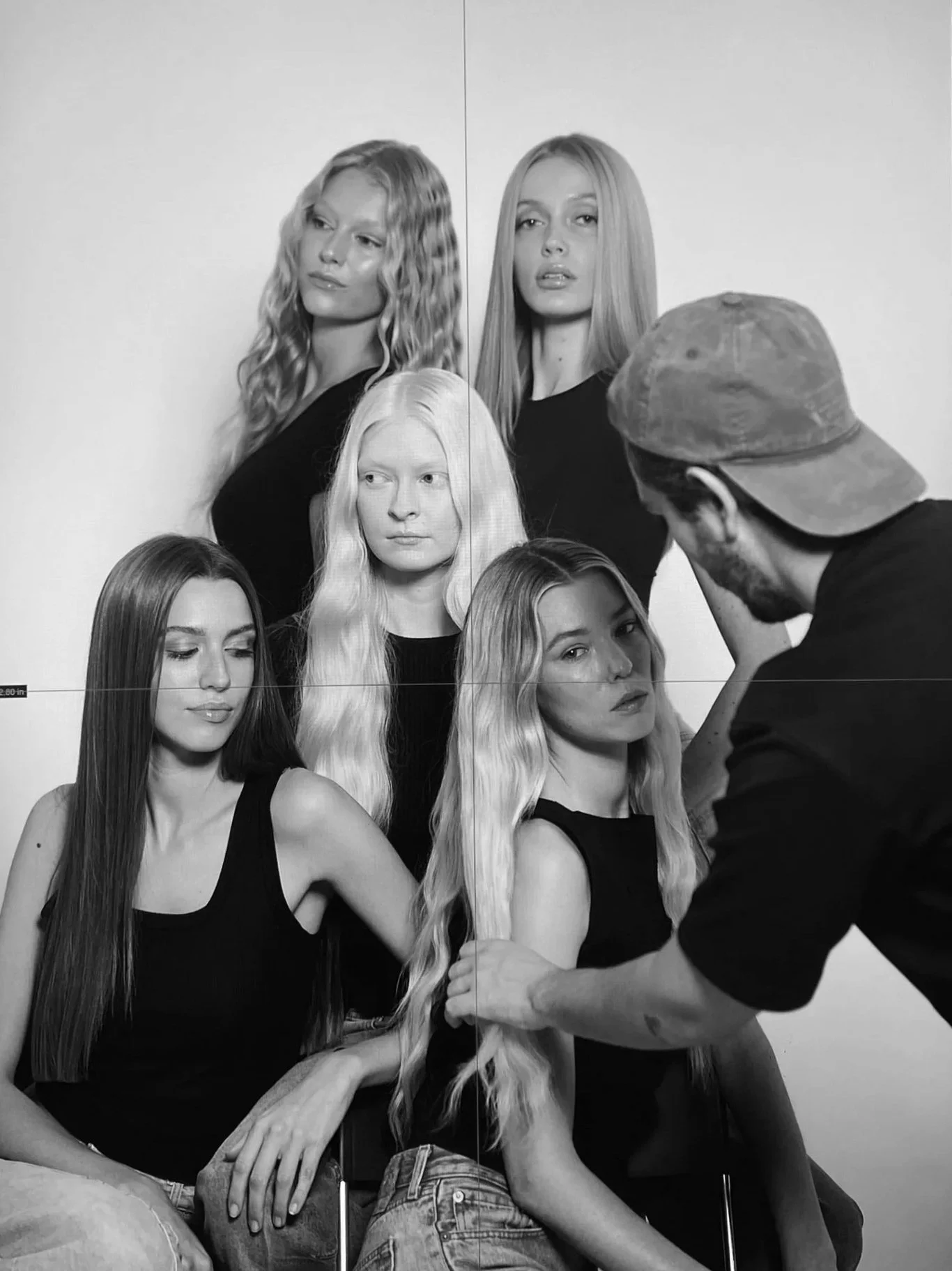 Photographer working on a black and white photoshoot of six women with long hair posing together.