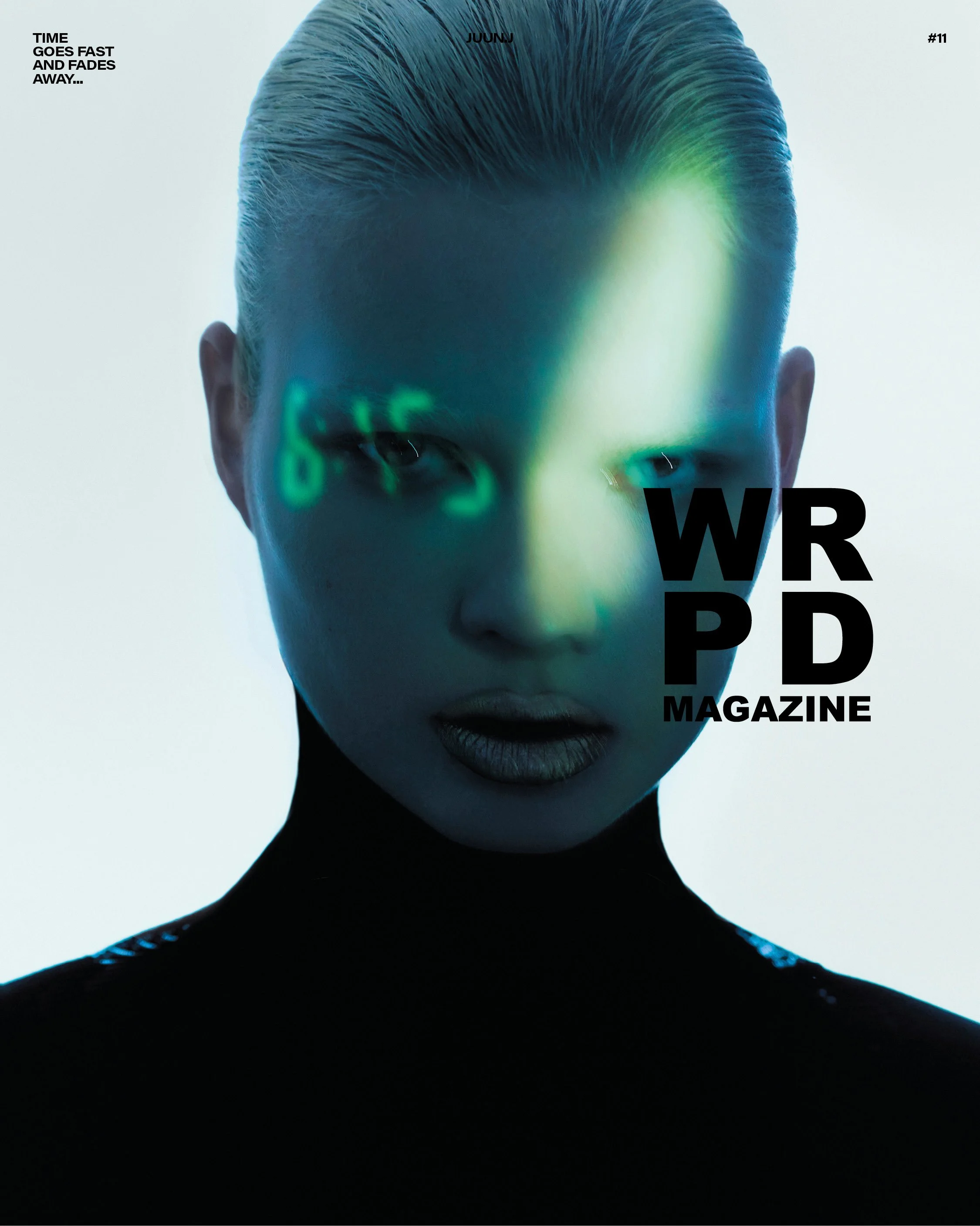 Close-up of a woman with platinum blonde hair, futuristic makeup, and an intense gaze. The photo has green and blue lighting effects projected onto her face, with text overlaying her face that reads 'WRP MAGAZINE' and additional small text at the top left corner that says 'TIME GOES FAST AND FADES AWAY...'.