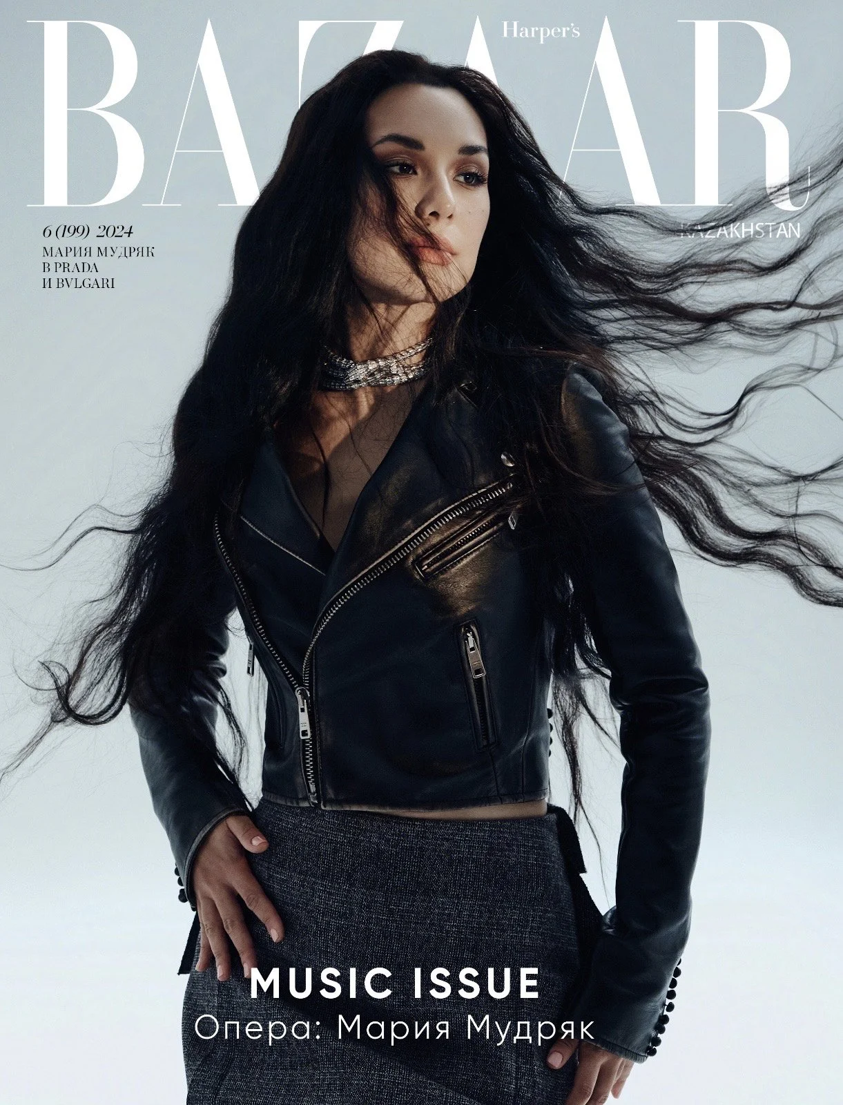 Cover of Harper's Bazaar magazine featuring Maria Mudryk in a black leather jacket and gray skirt, with long flowing hair, against a light background.