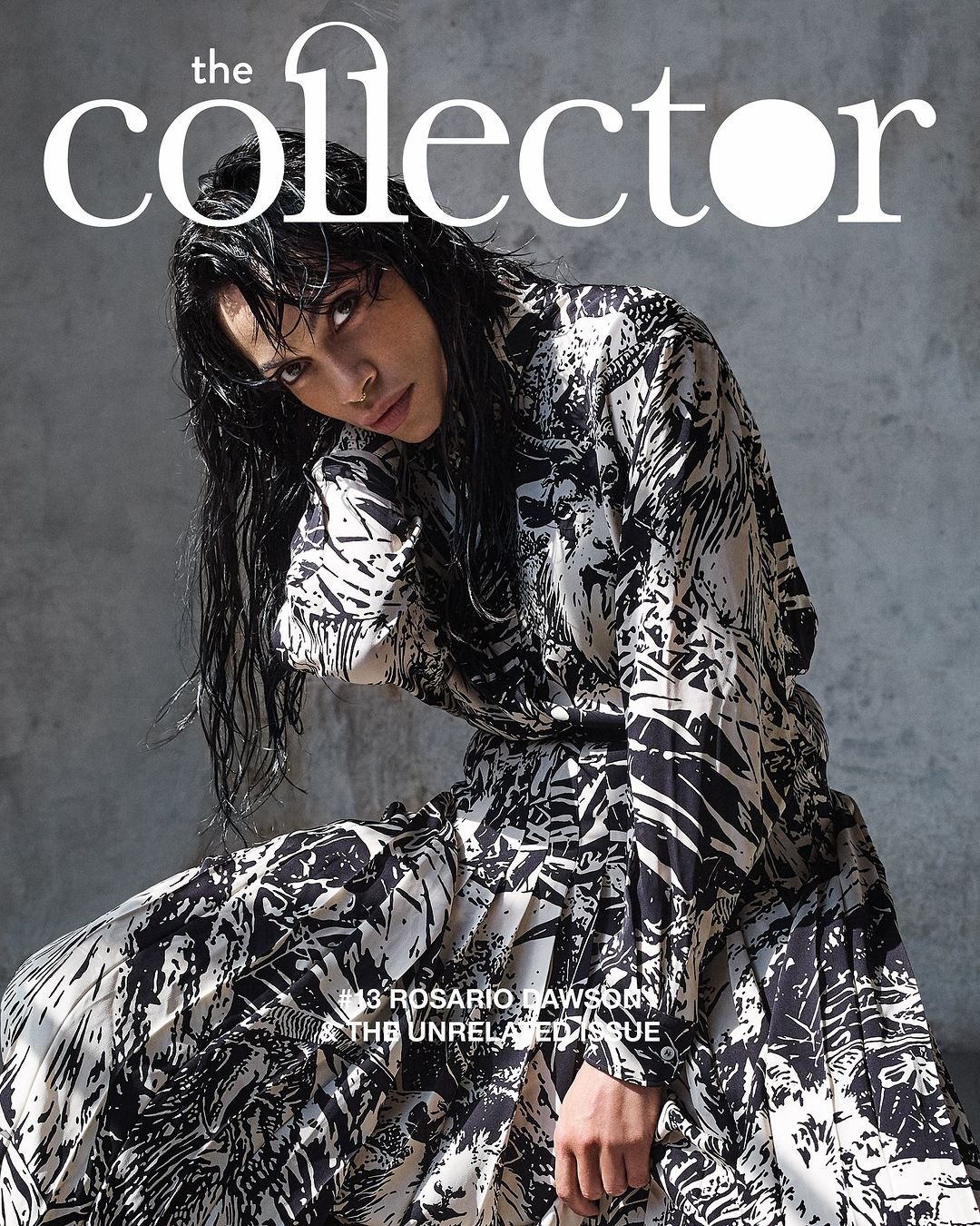 Fashion magazine cover featuring a woman with wet hair in a black and white abstract patterned outfit, leaning forward and looking at the camera against a gray background.