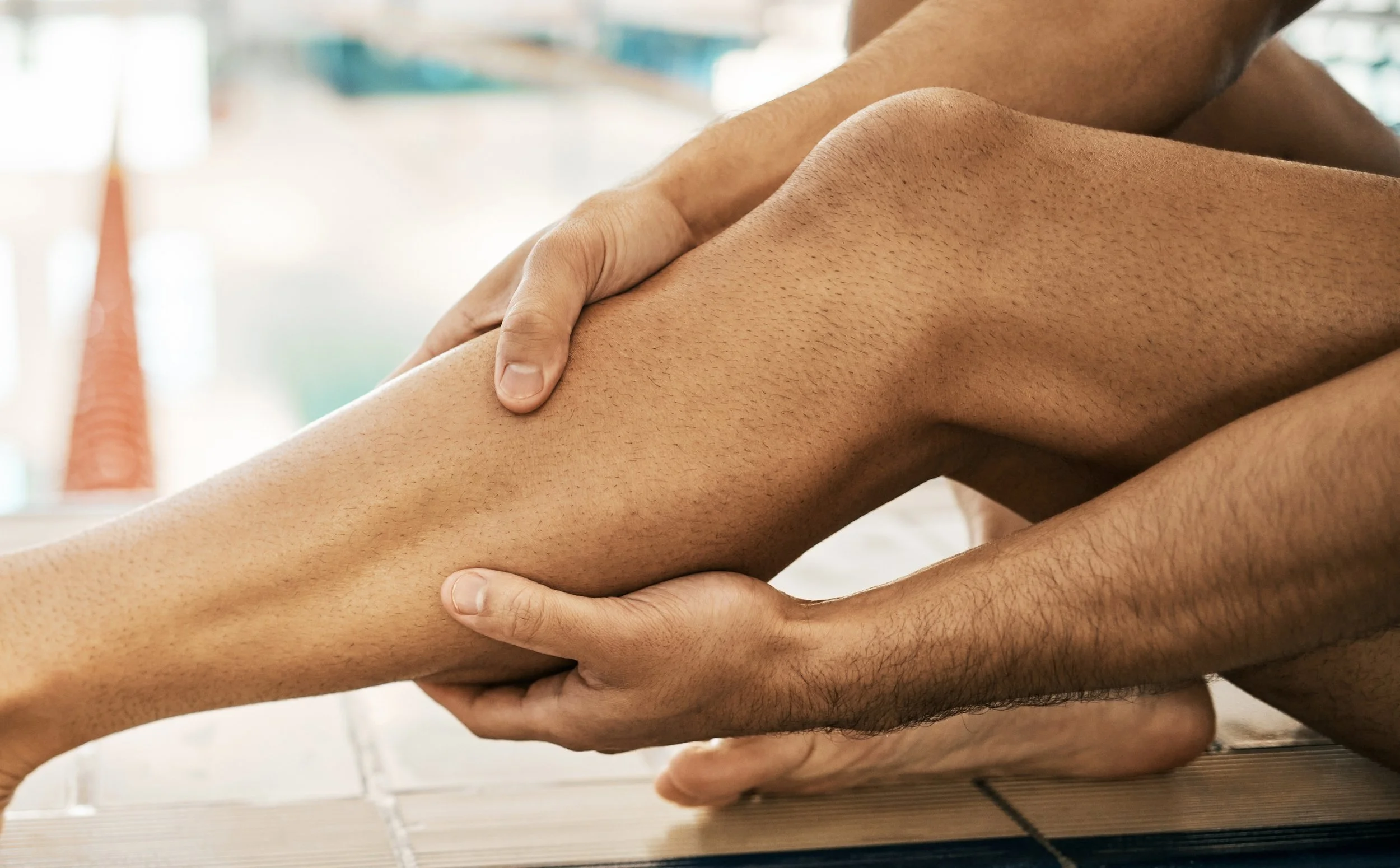 Hands preparing leg for soft wax treatment, close-up view.