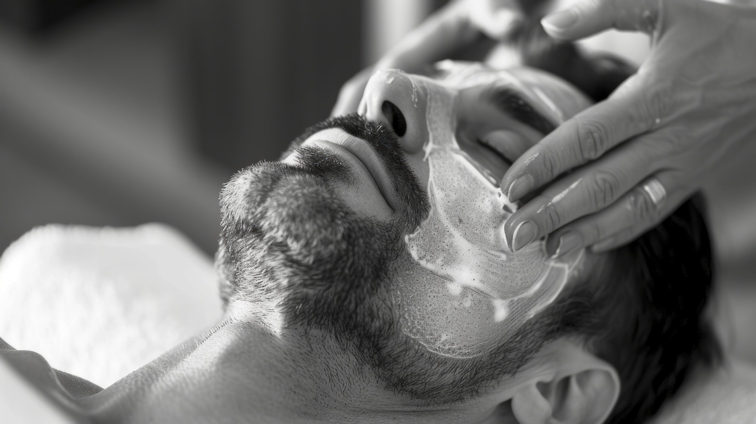 Man receiving facial treatment with foam mask