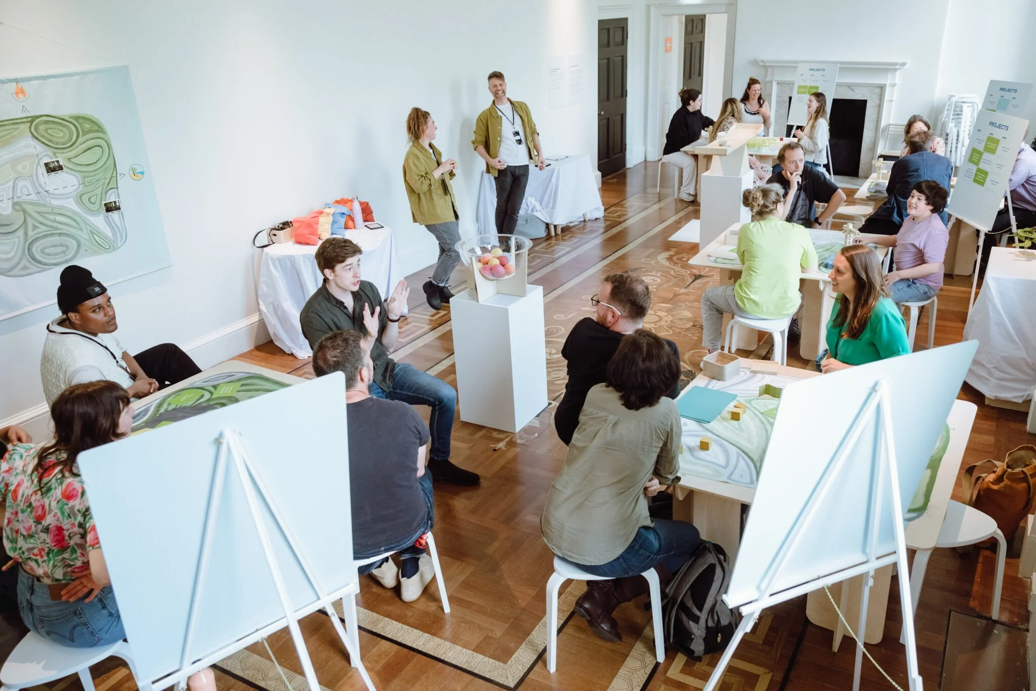 Groups of people at small tables playing a game.