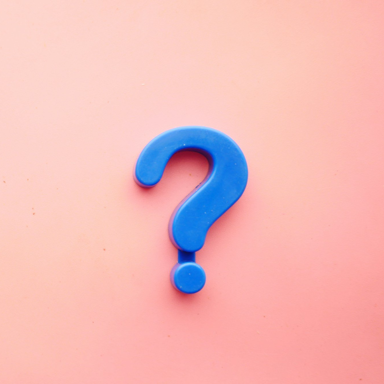 Blue plastic question mark on pink background.