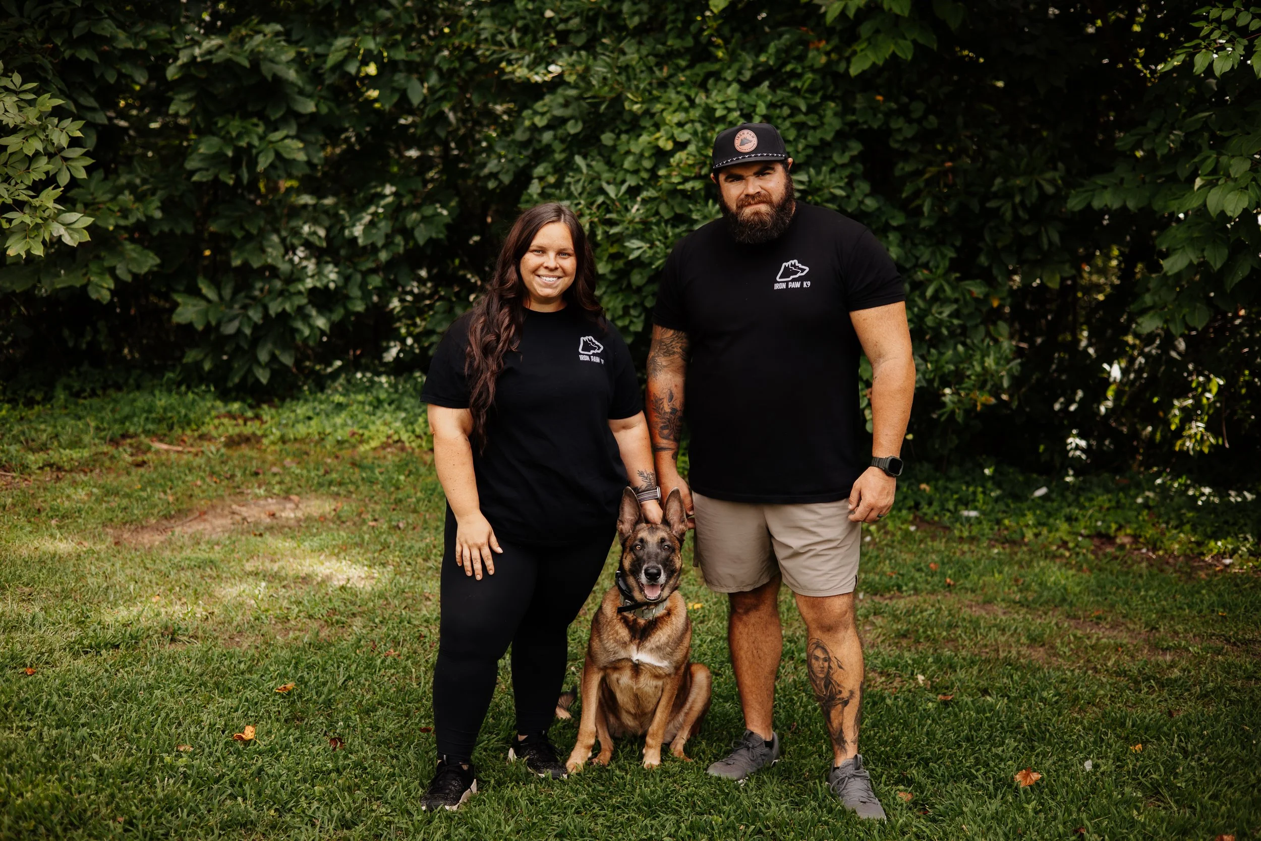 Blake and Sarah Forrester of Iron Paw K9 standing with a trained Belgian Malinois in Hall County, Georgia.