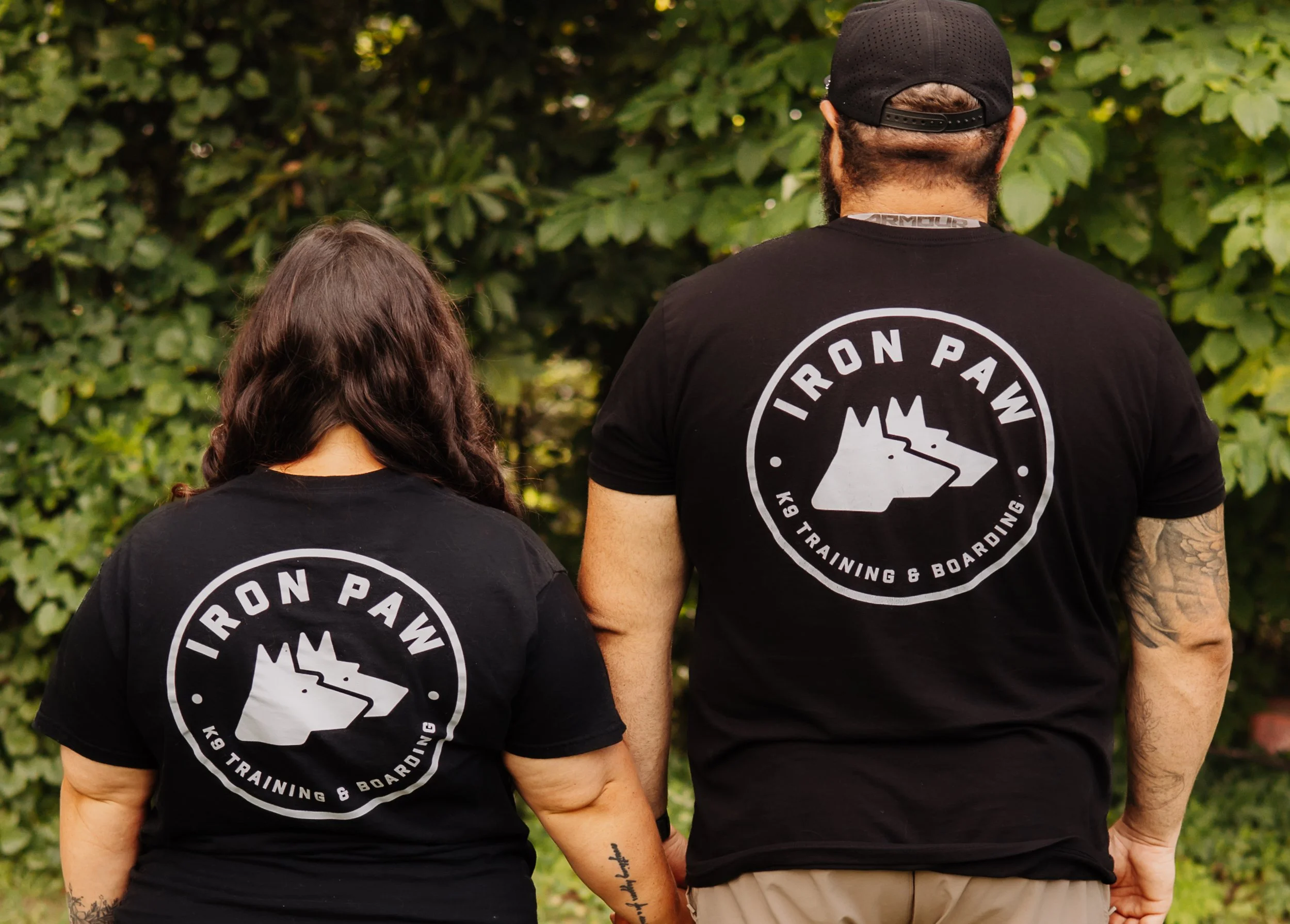 Branded Iron Paw K9 apparel worn by the owners at their professional dog training facility serving Hall County, Atlanta, and surrounding areas.